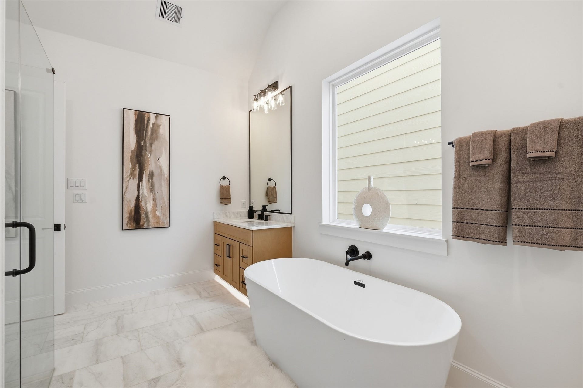 2111 Nantucket Drive, #C, Houston, TX 77057 A freestanding soaking tub anchors the primary bath, creating a peaceful retreat designed for slowing down and relaxing.