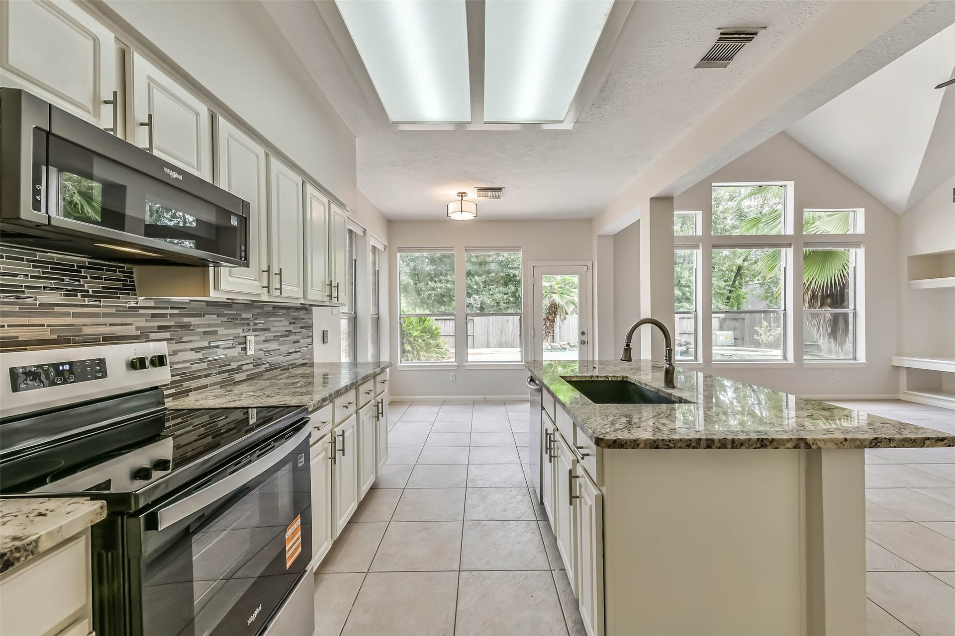 Pool views make even everyday kitchen routines feel a little brighter. The open connection to the living room and nearby backyard door makes it easy to take lunch outside or serve refreshments during an afternoon by the pool.