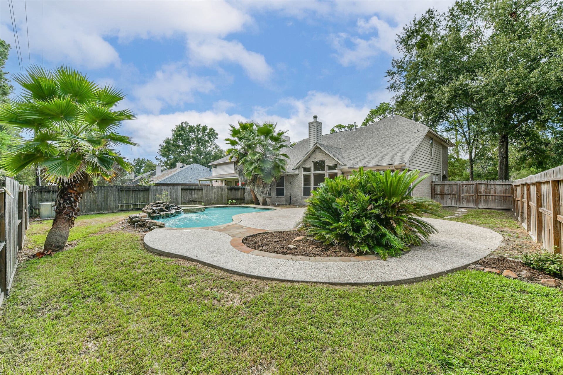 Make room for weekends outdoors with a pool, raised spa, and patio framed by mature palms. This wider backyard view highlights places to gather, unwind, and enjoy your own outdoor escape.