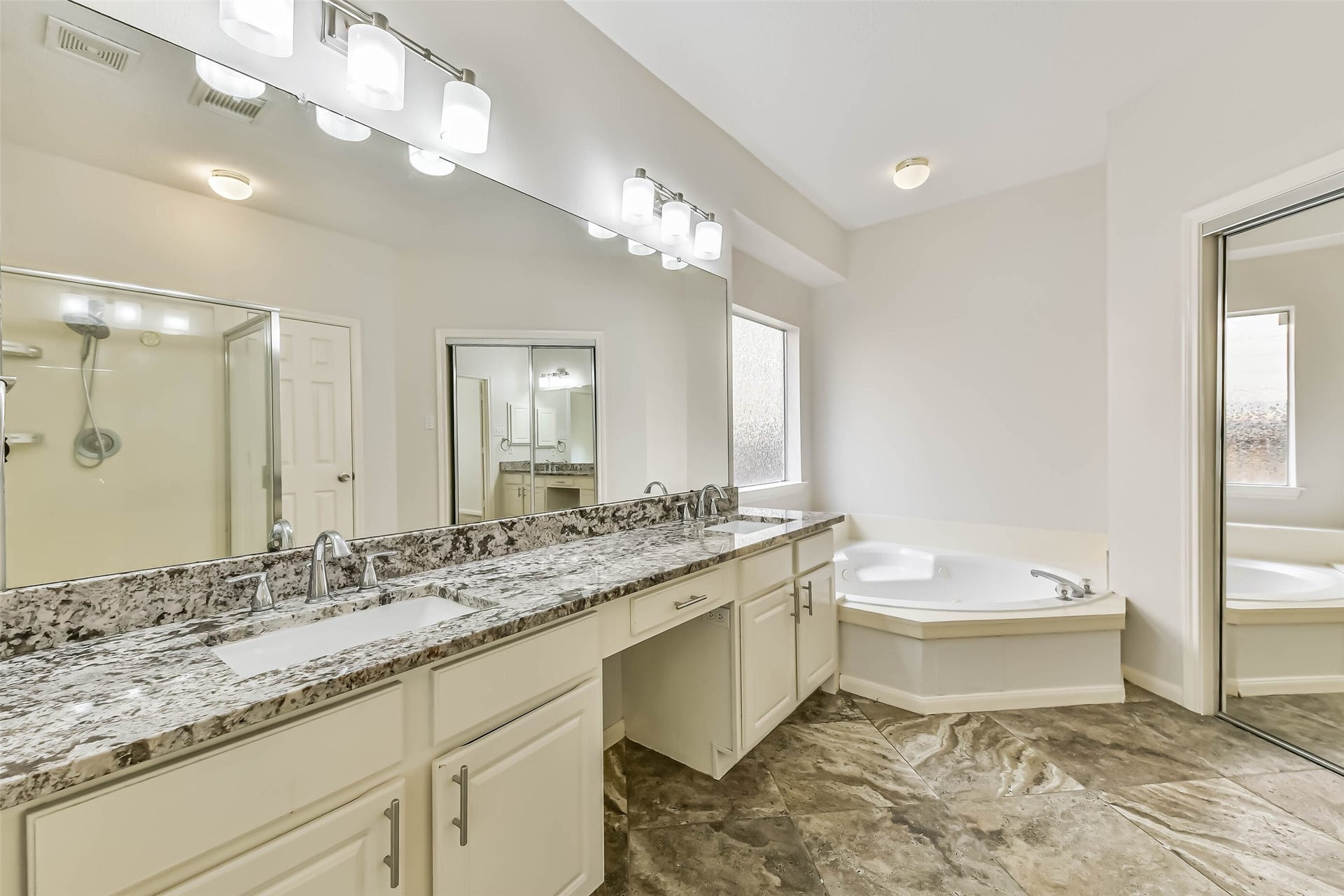 Give busy mornings a little more breathing room. Dual sinks, an extended countertop and a seated vanity area provide space to get ready, while the corner tub invites a slower pace at the end of the day.