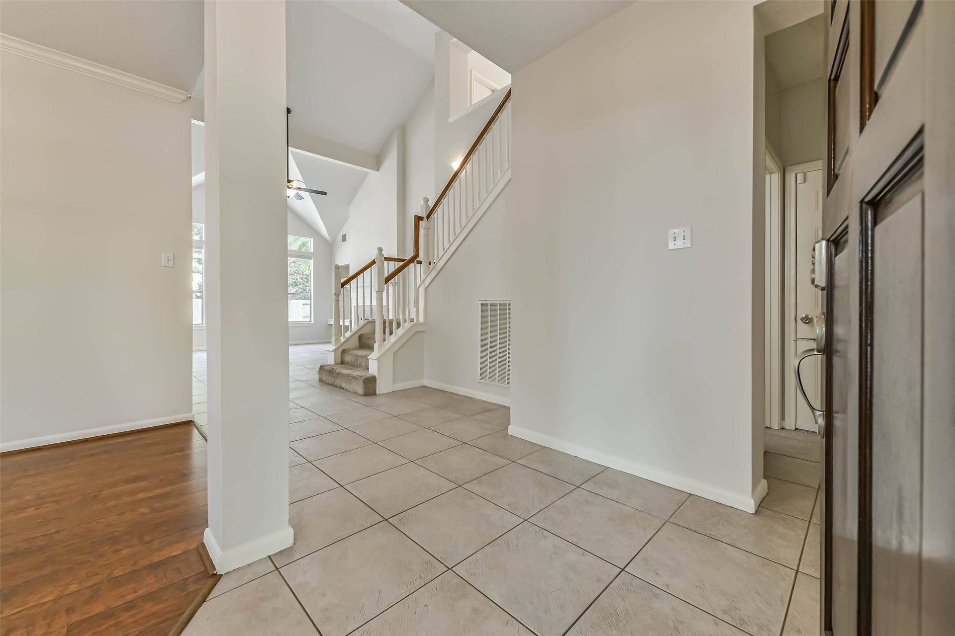 An airy entry welcomes you with tall ceilings and an immediate connection to the main living spaces. Tile flooring makes this busy arrival area easy to maintain, while the open staircase adds architectural character.