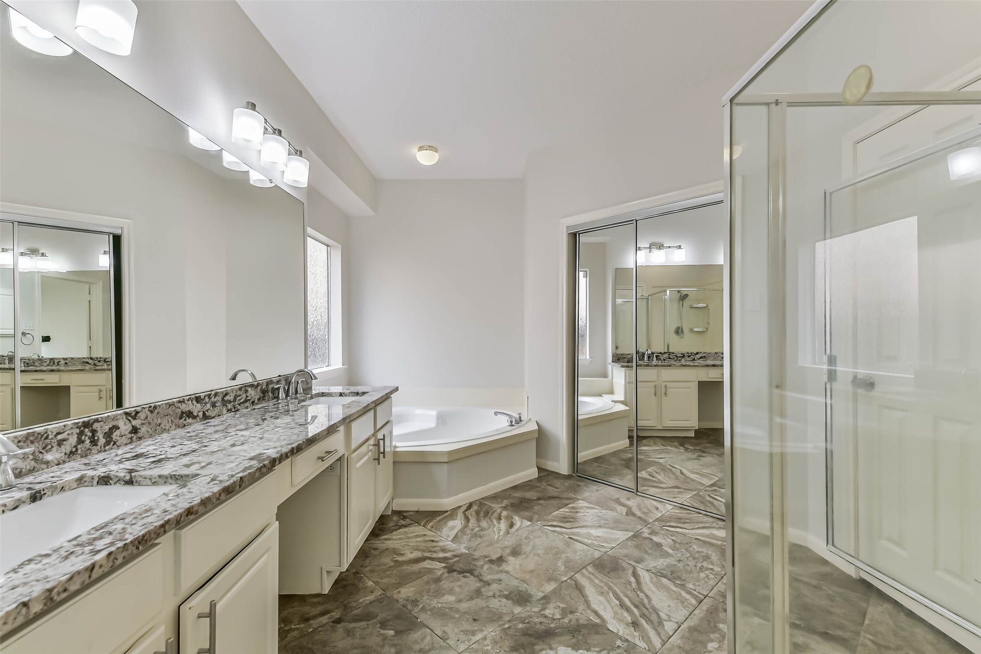 Choose a quick shower before heading out or a leisurely soak when the day is done. Separate bathing spaces, generous vanity storage and a large mirror make this private bath a practical place to start and finish your day.