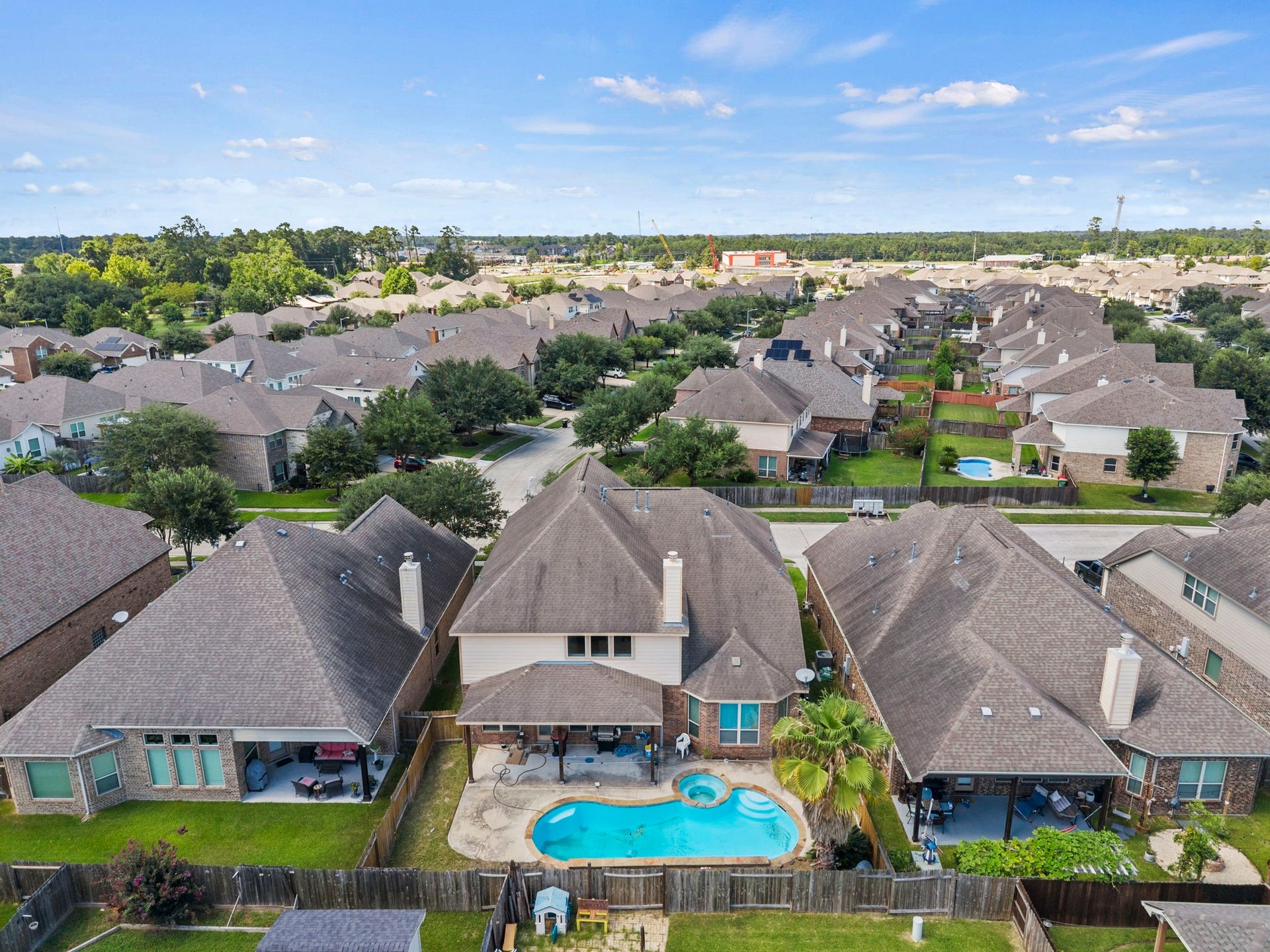 26111 Tintagel Lane, Kingwood, TX 77339 Backyard paradise awaits with a stunning freeform pool, spa, and covered patio, your own private retreat overlooking a sprawling, tree-filled community!