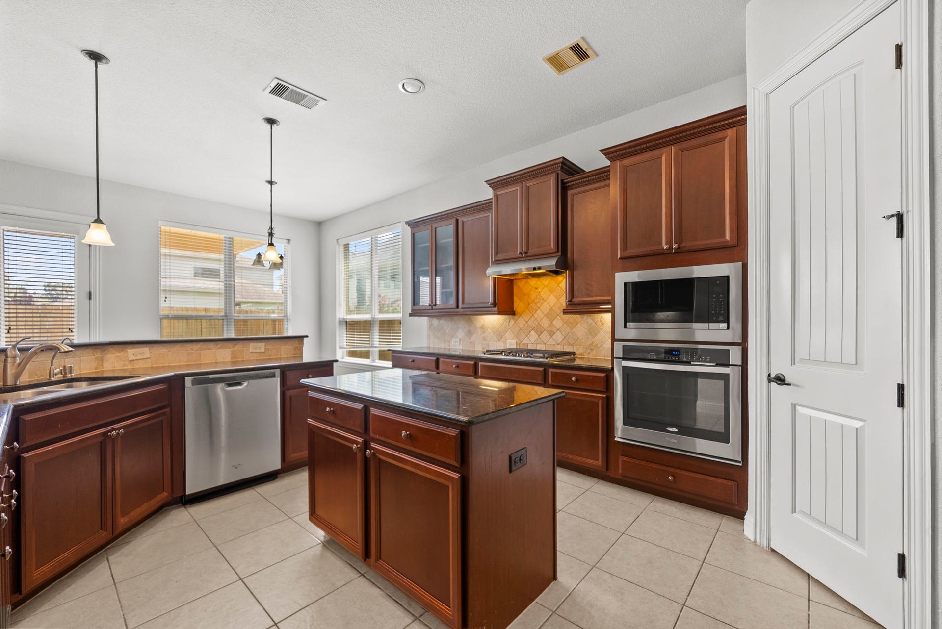 26111 Tintagel Lane, Kingwood, TX 77339 Chef-ready kitchen dazzles with rich cherry cabinetry, gleaming stainless steel appliances, and a center island ideal for prepping and gathering!