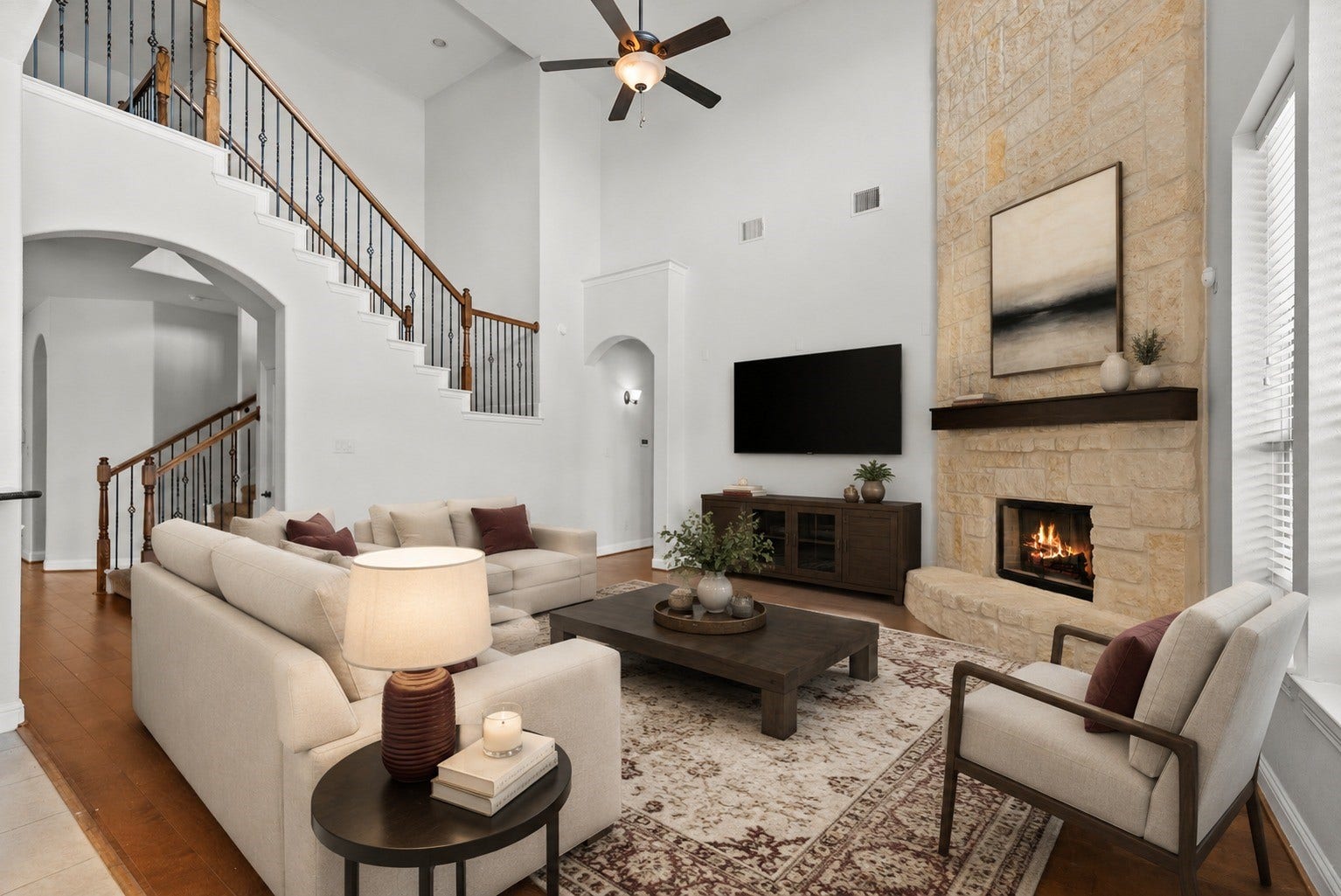 26111 Tintagel Lane, Kingwood, TX 77339 Virtually Stagged - Soaring two-story living room dazzles with a dramatic floor-to-ceiling stone fireplace, elegant wrought-iron staircase, and rich hardwood floors throughout!