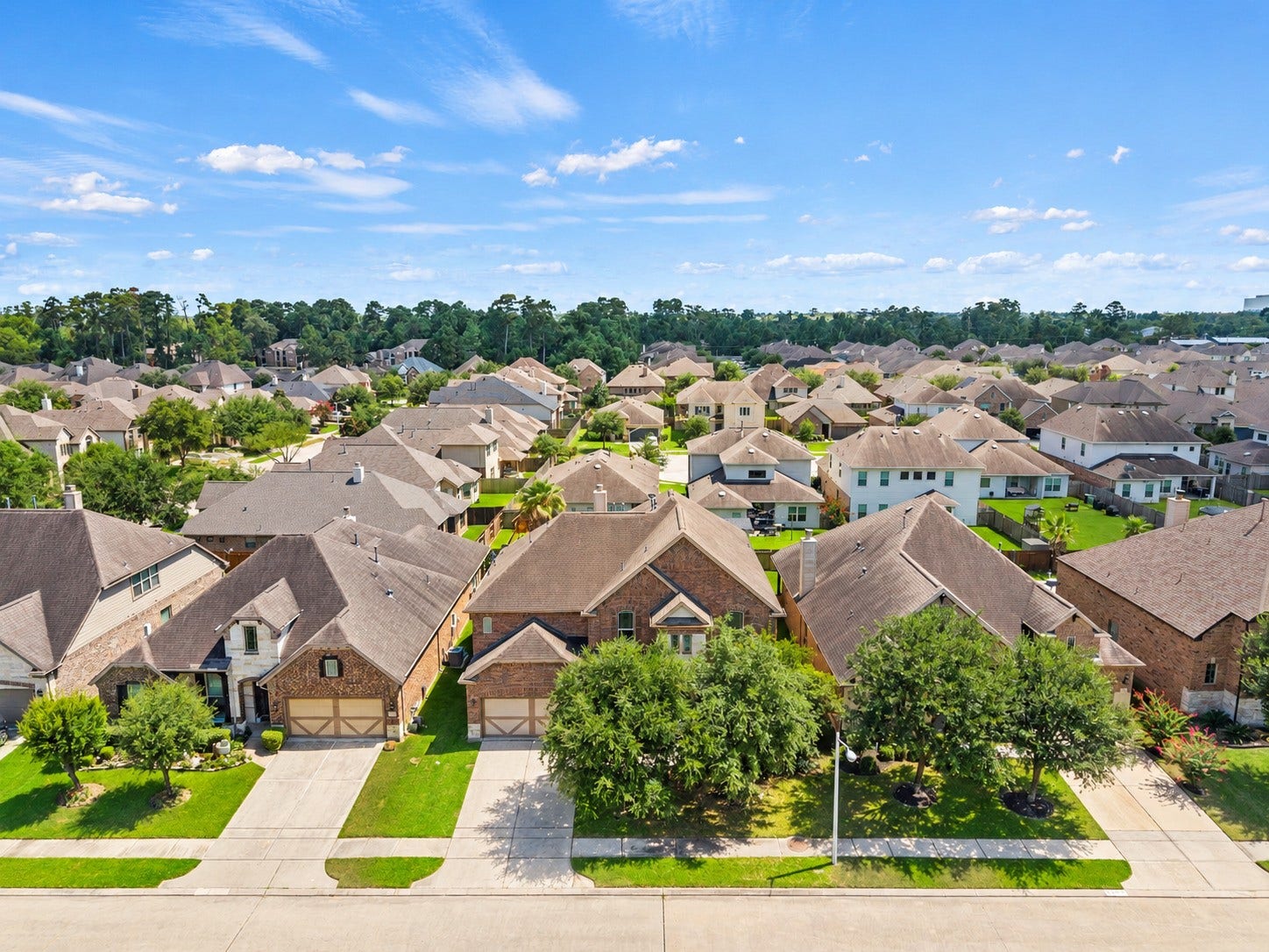 26111 Tintagel Lane, Kingwood, TX 77339 Stunning aerial view showcases this beautiful brick home nestled in a desirable, tree-lined community with lush greenery as far as the eye can see!