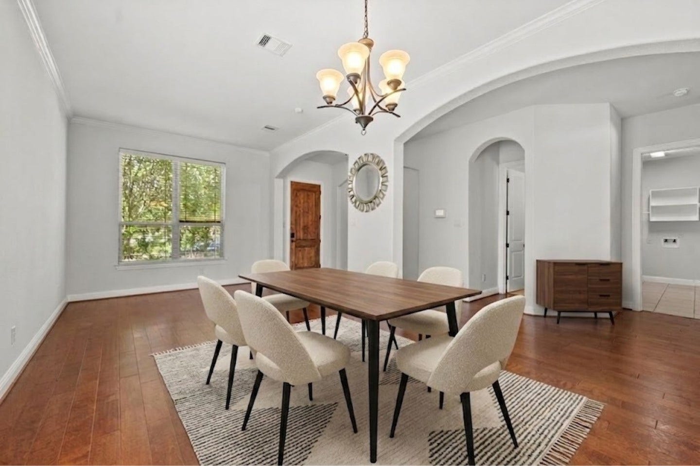 26111 Tintagel Lane, Kingwood, TX 77339 Virtually Stagged - Sun drenched entry showcases a beautiful chandelier, graceful archways, and warm hardwood floors flowing seamlessly into the heart of the home!
