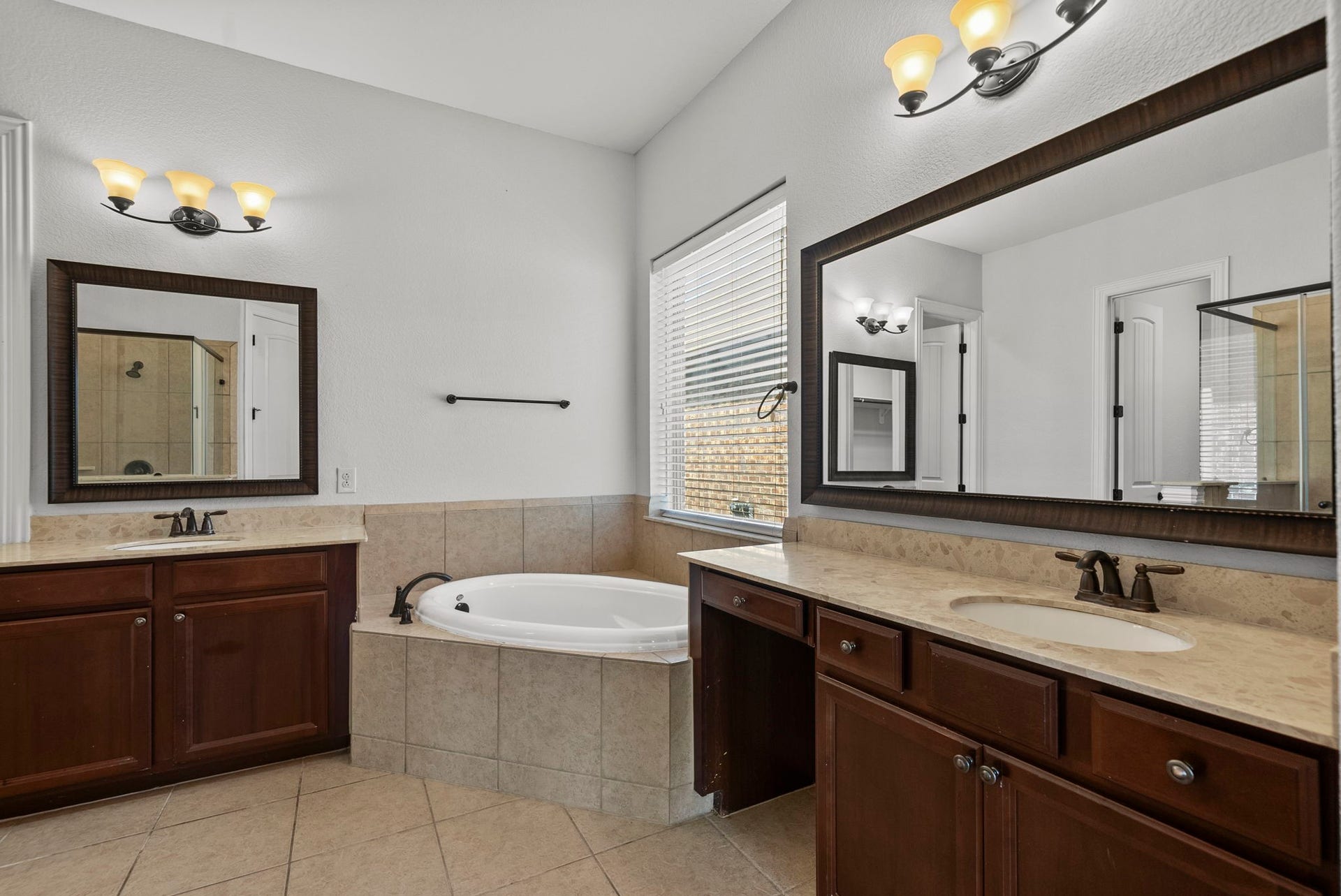 26111 Tintagel Lane, Kingwood, TX 77339 Luxurious ensuite bath indulges with dual vanities, a relaxing soaking tub, and elegant designer finishes throughout, a true spa-inspired retreat!