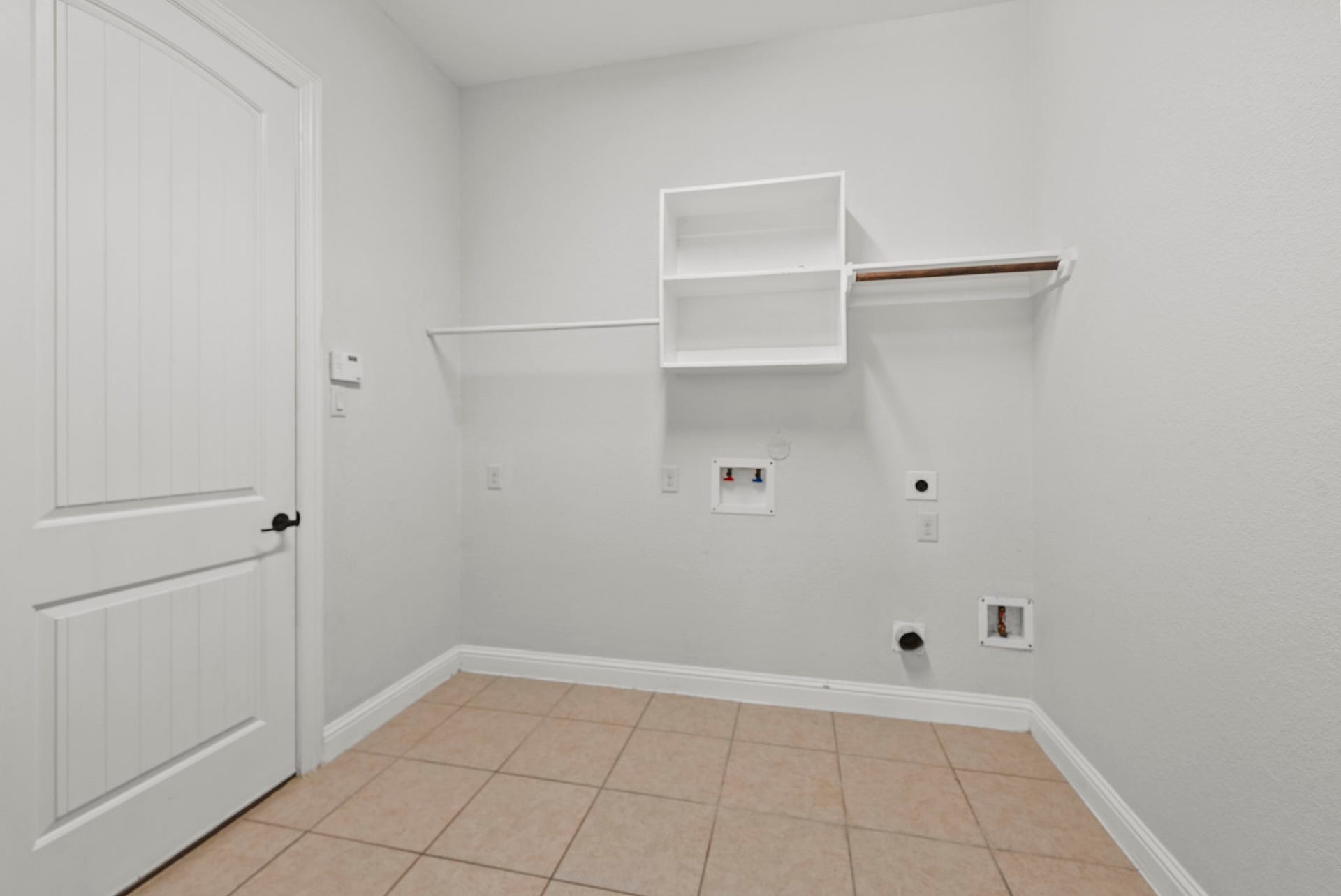 26111 Tintagel Lane, Kingwood, TX 77339 Convenient dedicated laundry room offers built-in shelving and hanging space, practical, everyday functionality with a tidy tile floor!