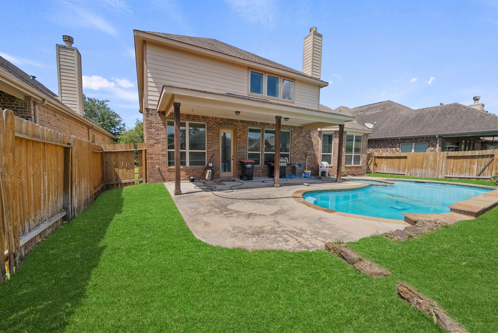 26111 Tintagel Lane, Kingwood, TX 77339 Private, fully fenced backyard retreat features a sparkling pool, spacious covered patio, and lush green lawn, outdoor living at its finest!