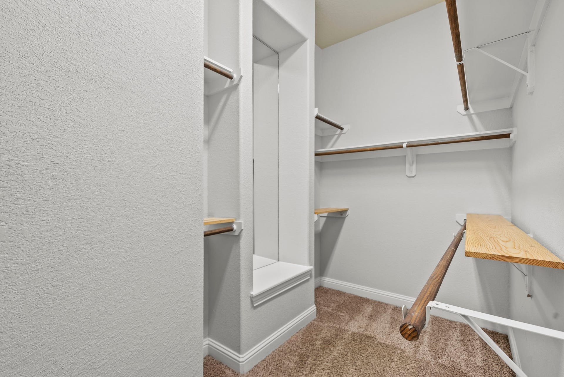 26111 Tintagel Lane, Kingwood, TX 77339 Walk-in closet features a built-in mirror nook and multiple hanging levels, thoughtful storage designed for effortless organization!