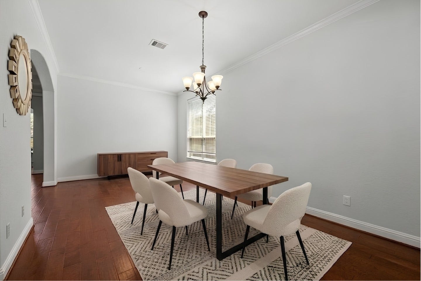 26111 Tintagel Lane, Kingwood, TX 77339 Virtually Stagged - Elegant formal dining room boasts gleaming hardwood floors, an elegant chandelier, and crisp crown molding, ready to host memorable gatherings!