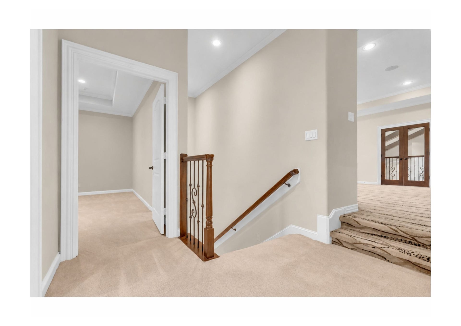Upper-level stairs landing with custom ironwork and architectural details. Bedroom # 5 straight ahead & flex-family-game room to the right.