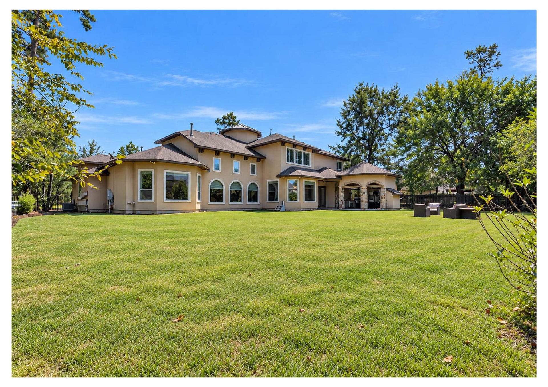 Almost a half-acre lot, oversized backyard showcasing the homes impressive rear elevation and beautiful wooded setting