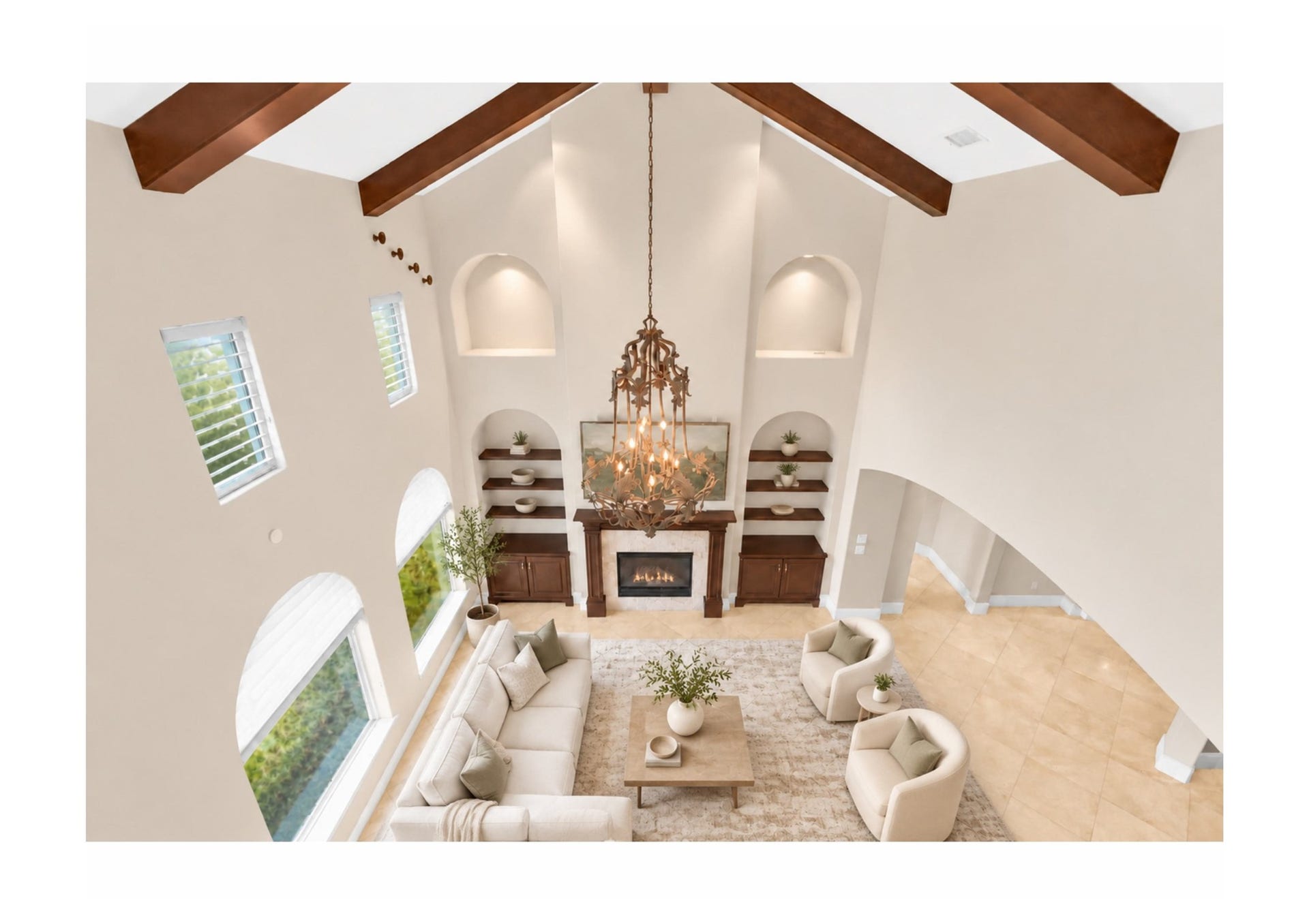 Dramatic two-story living room with soaring beamed ceilings and custom built-ins.