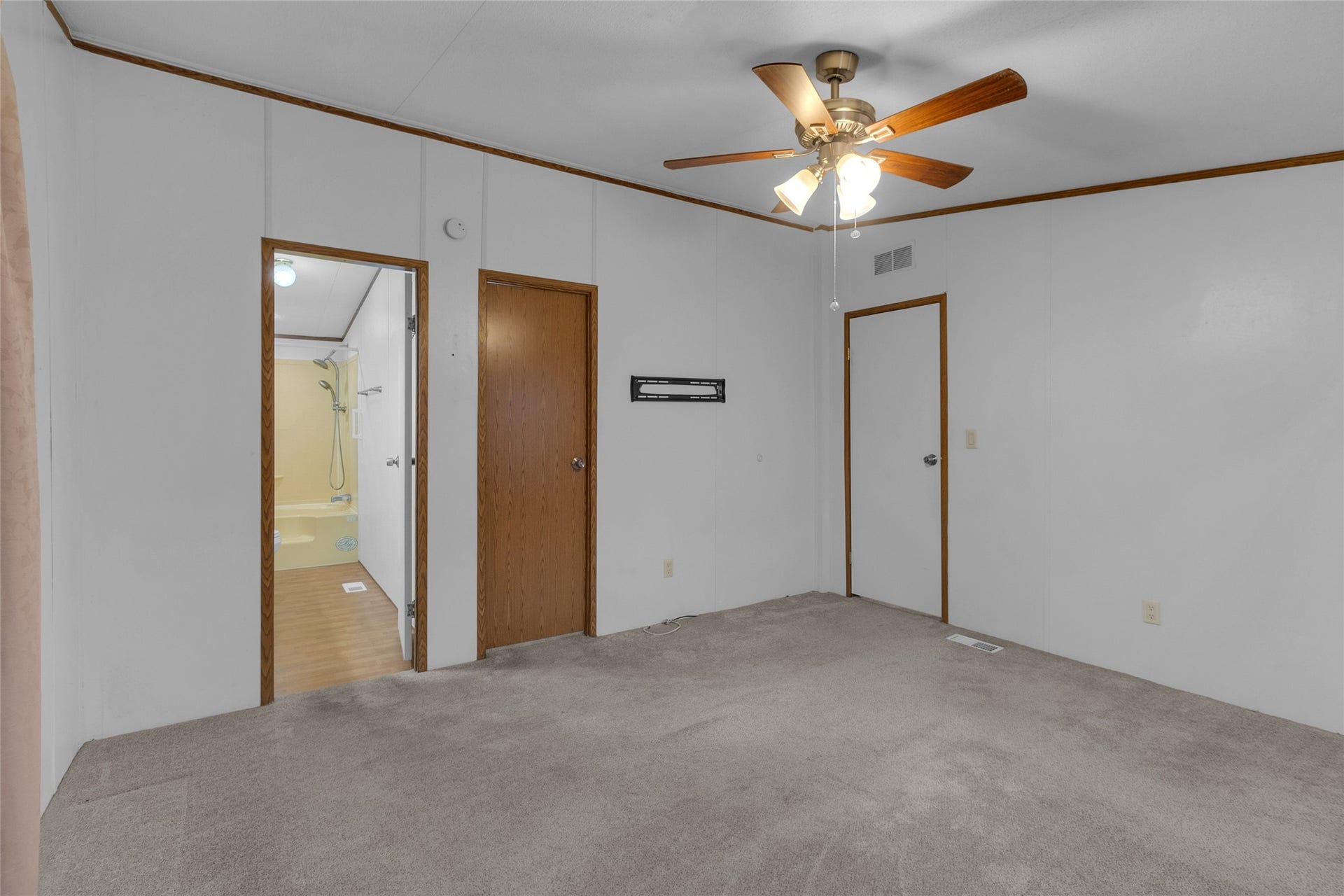 Primary bedroom featuring a spacious layout with a walk-in closet and a entry doorway leading to the primary bathroom.