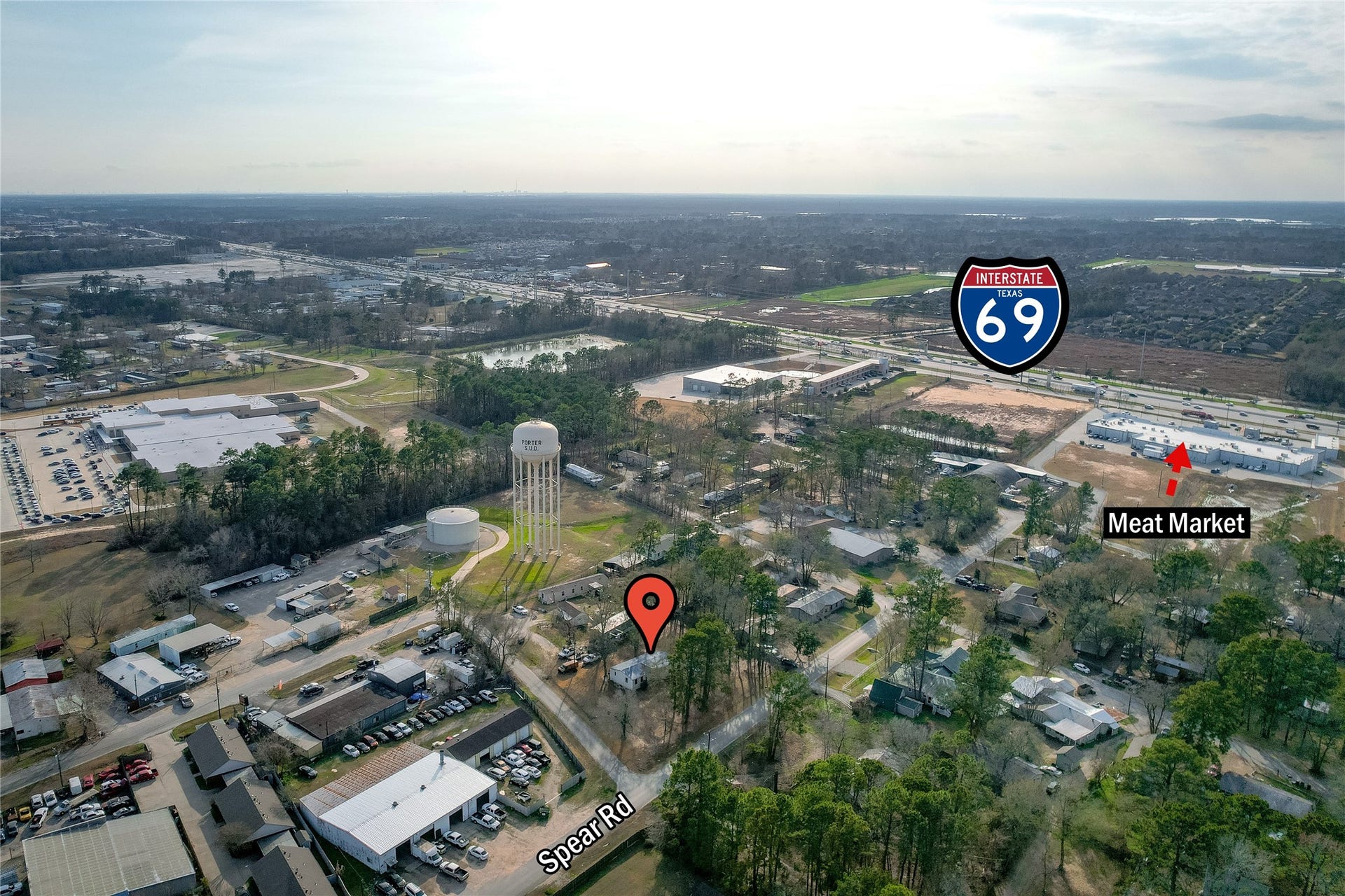 This aerial photo showcases a residential area near Spear Rd, with easy access to Interstate 69. The neighborhood features lush greenery and a meat market for convenient shopping. Ideal for those seeking a blend of suburban living with quick highway access.