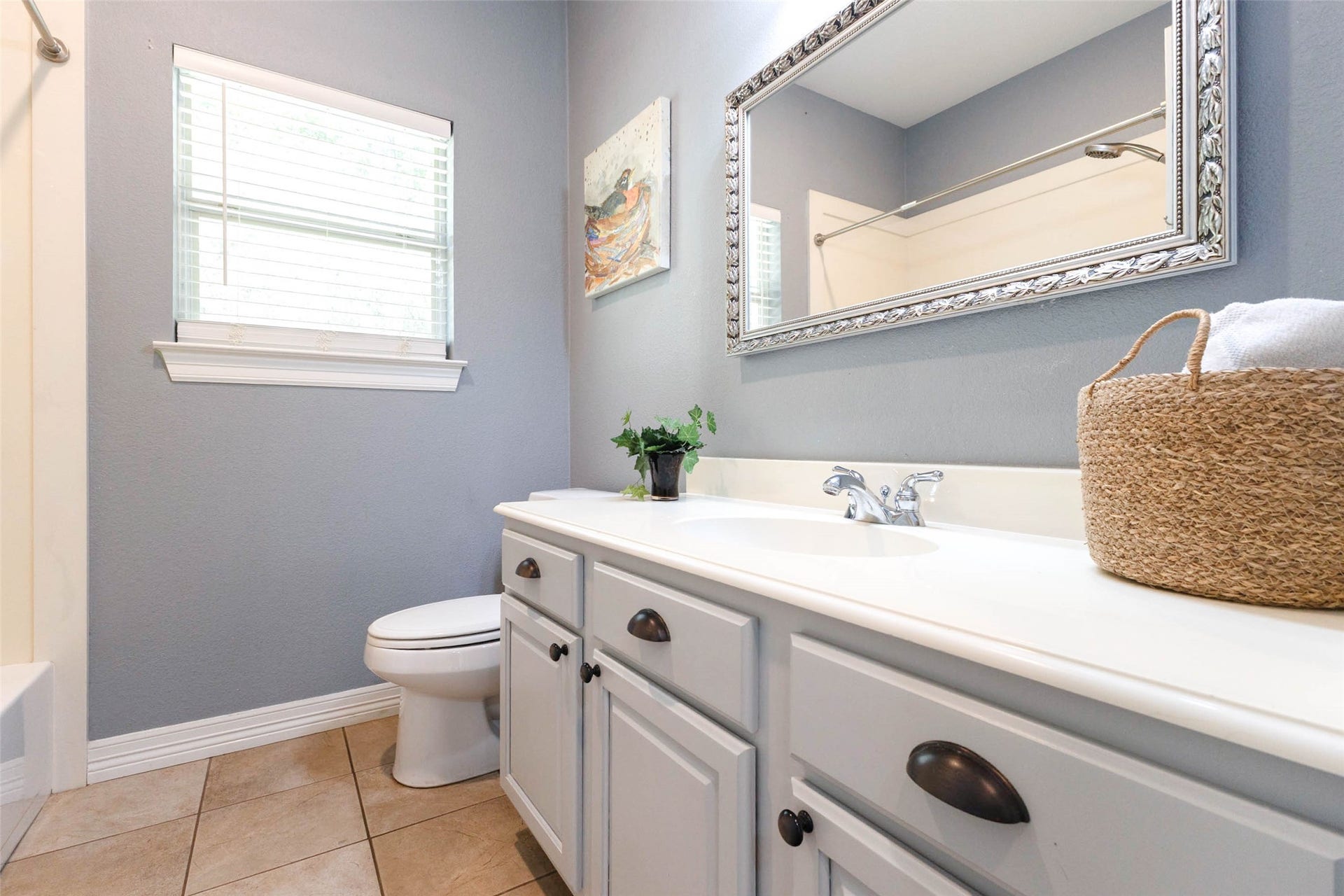 346 Skylark Street, Magnolia, TX 77355 The secondary full bath offers ample cabinet storage, tile flooring, a spacious mirror, and natural light from the window.