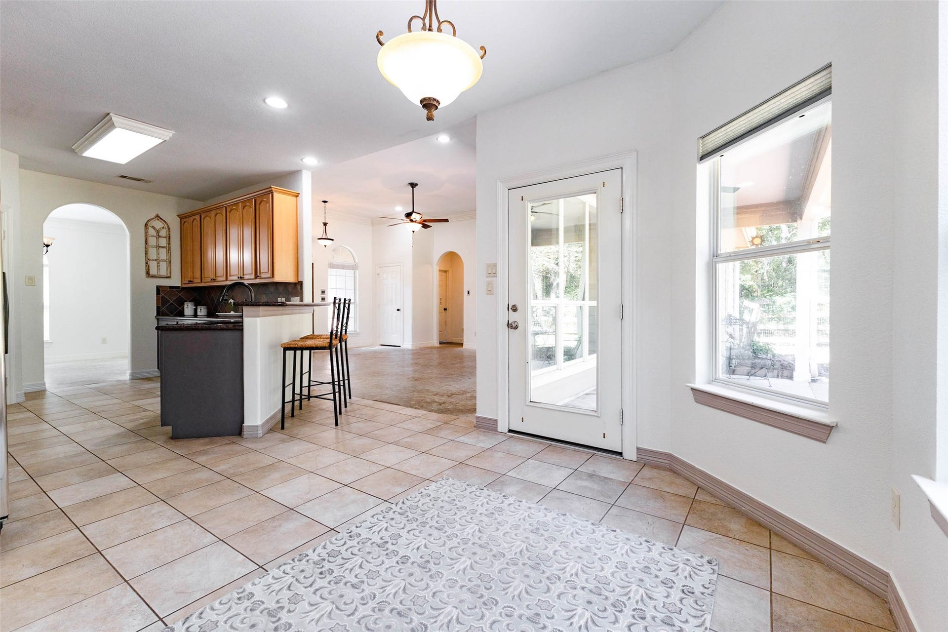 346 Skylark Street, Magnolia, TX 77355 The breakfast area offers a cheerful spot for morning coffee, with natural light streaming through the windows and a glass-paneled door leading directly to the covered back patio. Tile flooring continues throughout the kitchen and breakfast area.