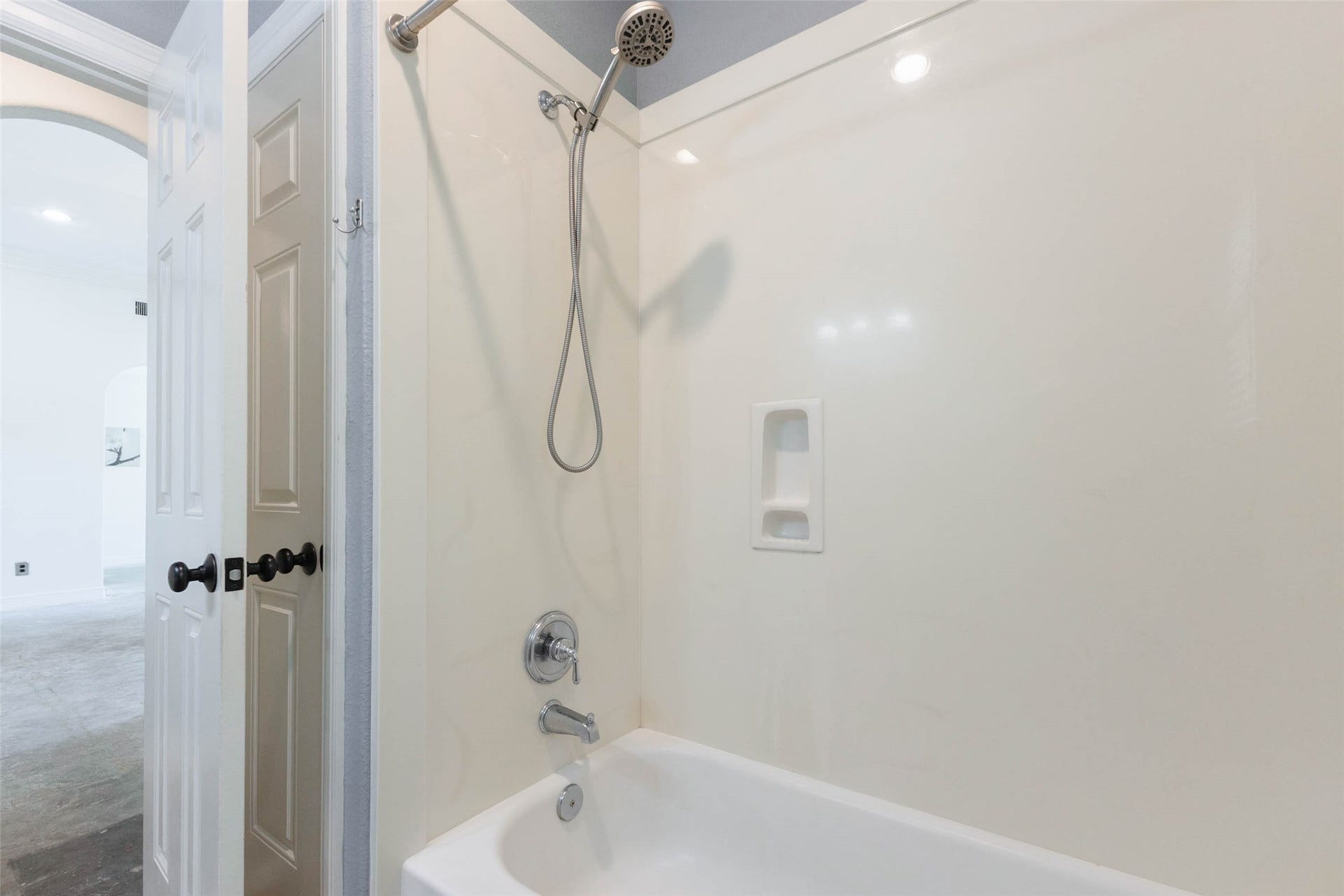 346 Skylark Street, Magnolia, TX 77355 A closer look at the tub/shower combination featuring a handheld showerhead and built-in niches for bath essentials. A large linen closet provides additional storage.