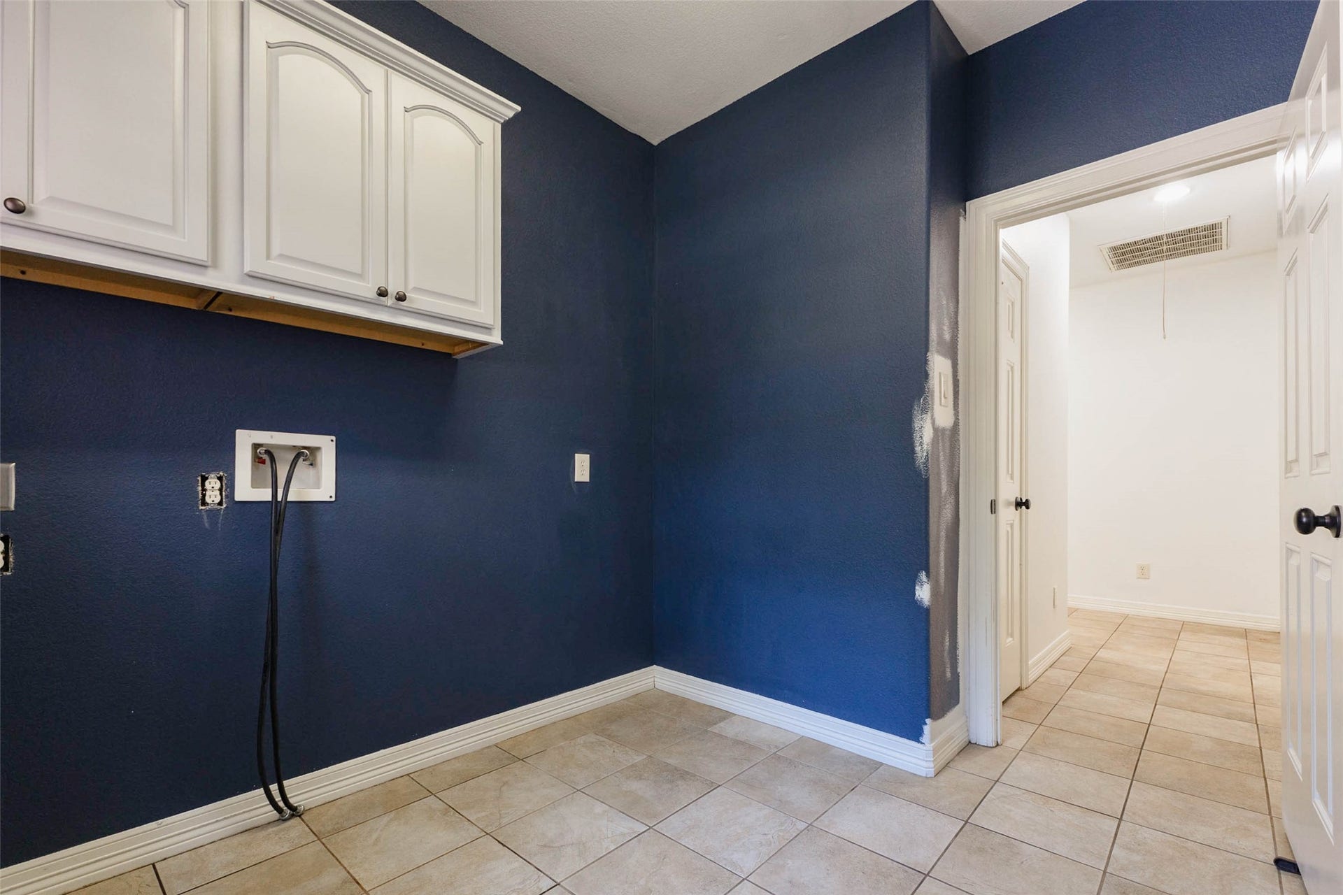 346 Skylark Street, Magnolia, TX 77355 The spacious 8' x 10' utility room offers ample space for a washer, dryer, and additional refrigerator, along with overhead cabinetry for storage and tile flooring.