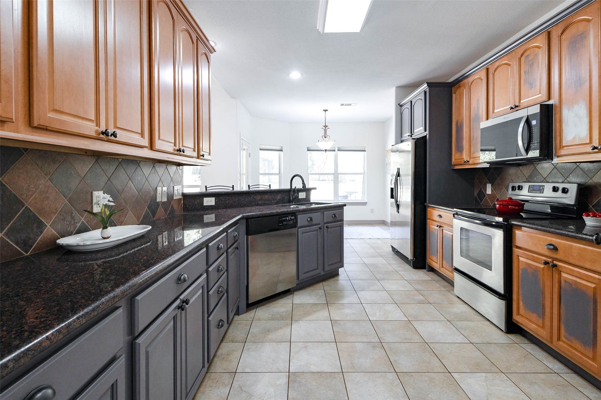 346 Skylark Street, Magnolia, TX 77355 The kitchen features granite countertops, tile backsplash, stainless steel appliances, and a breakfast bar overlooking the living area. There's plenty of cabinet and counter space, with a breakfast area tucked away at the far end of the kitchen.