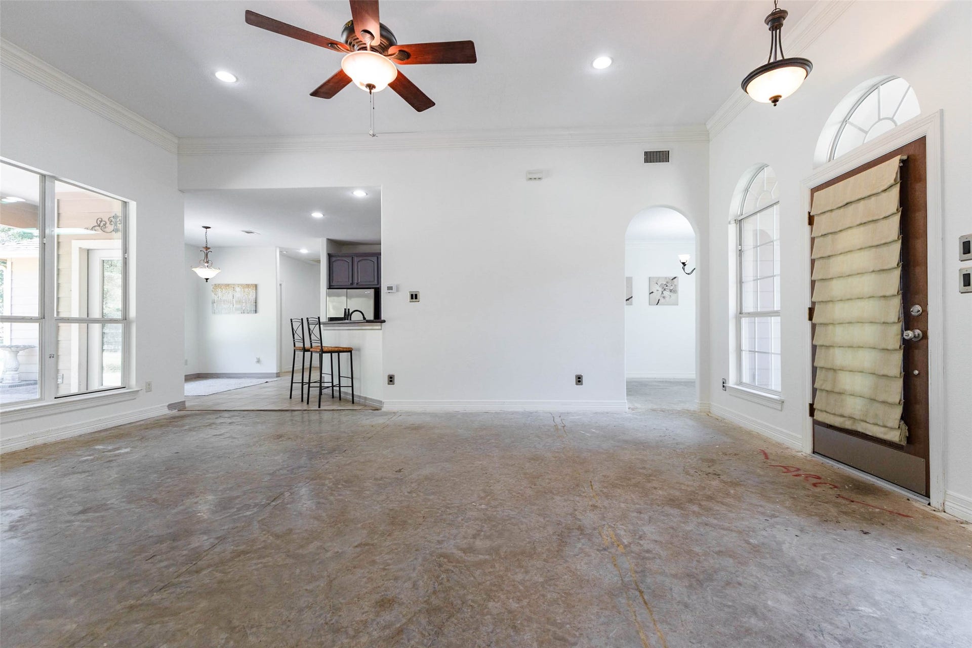 346 Skylark Street, Magnolia, TX 77355 Looking toward the front entrance, this view highlights the home's open layout, with easy access to the dining area and kitchen. Arched doorways and windows, crown molding, and abundant natural light give this space plenty of character.