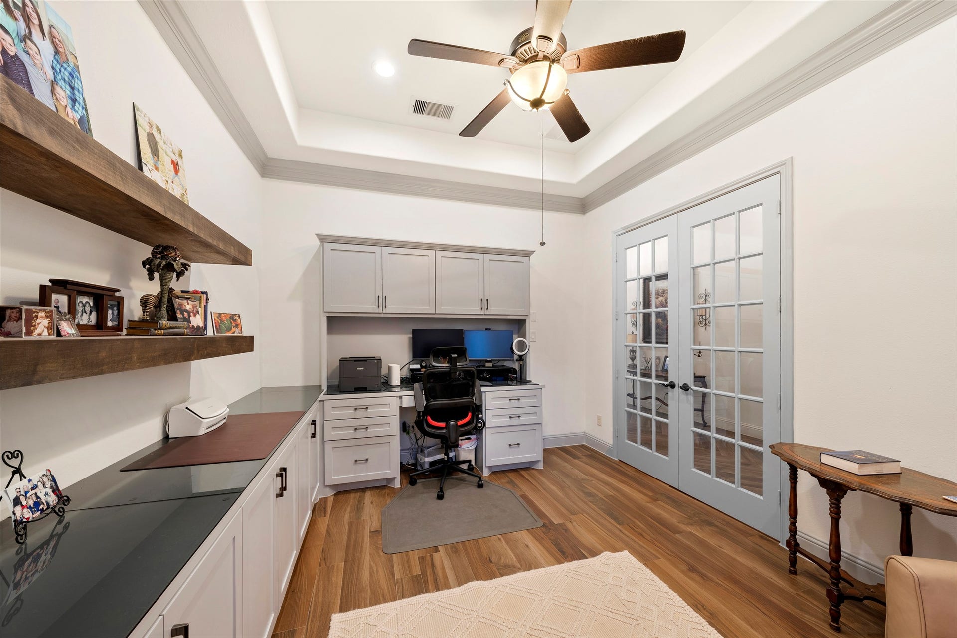 Bright home office with elegant French doors, built-in cabinets, and rich wood flooring, offering a functional and stylish workspace.