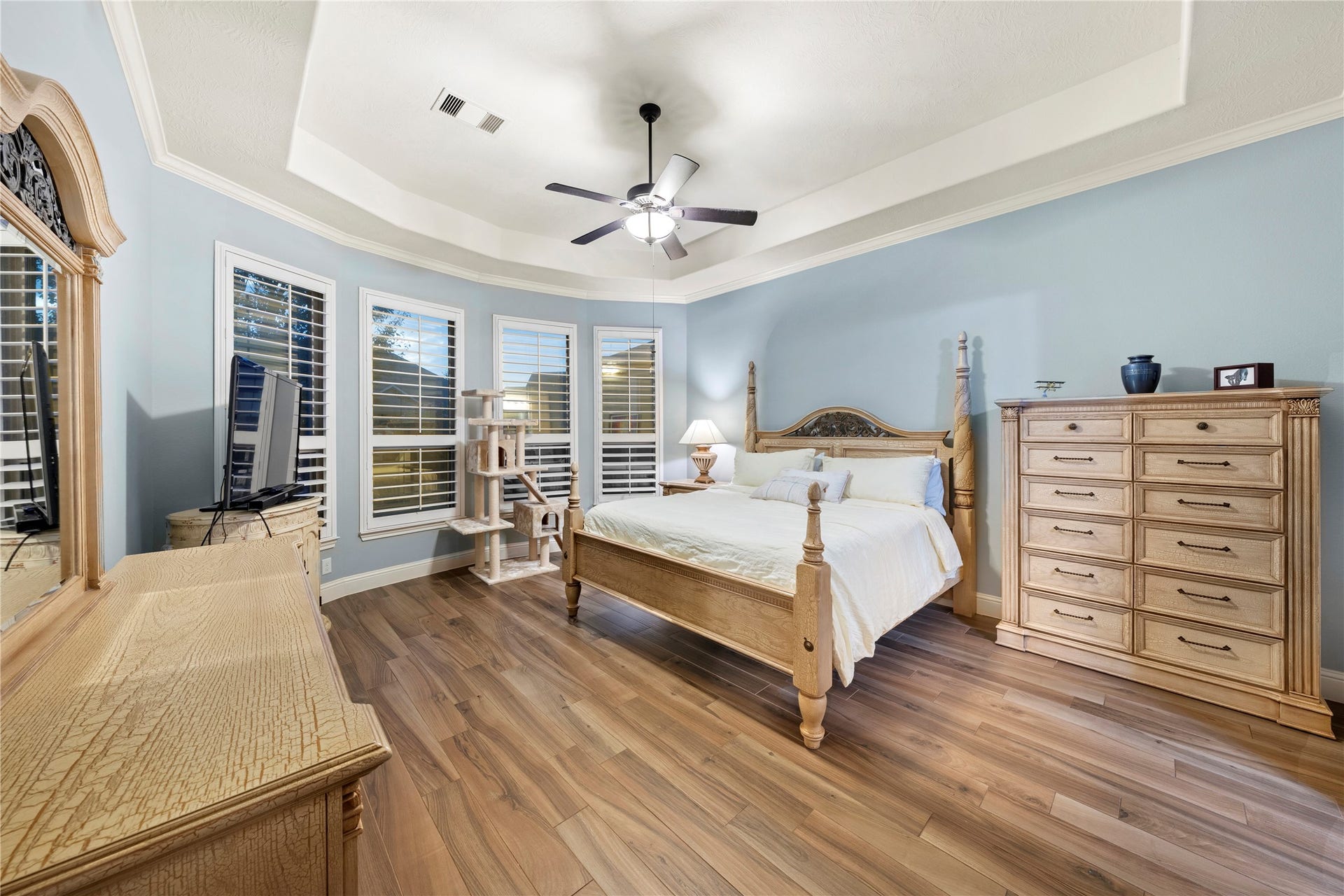 Here is your private oasis in the primary bedroom, featuring elegant Italian tile floors, abundant natural light, and a stylish coffered ceiling.