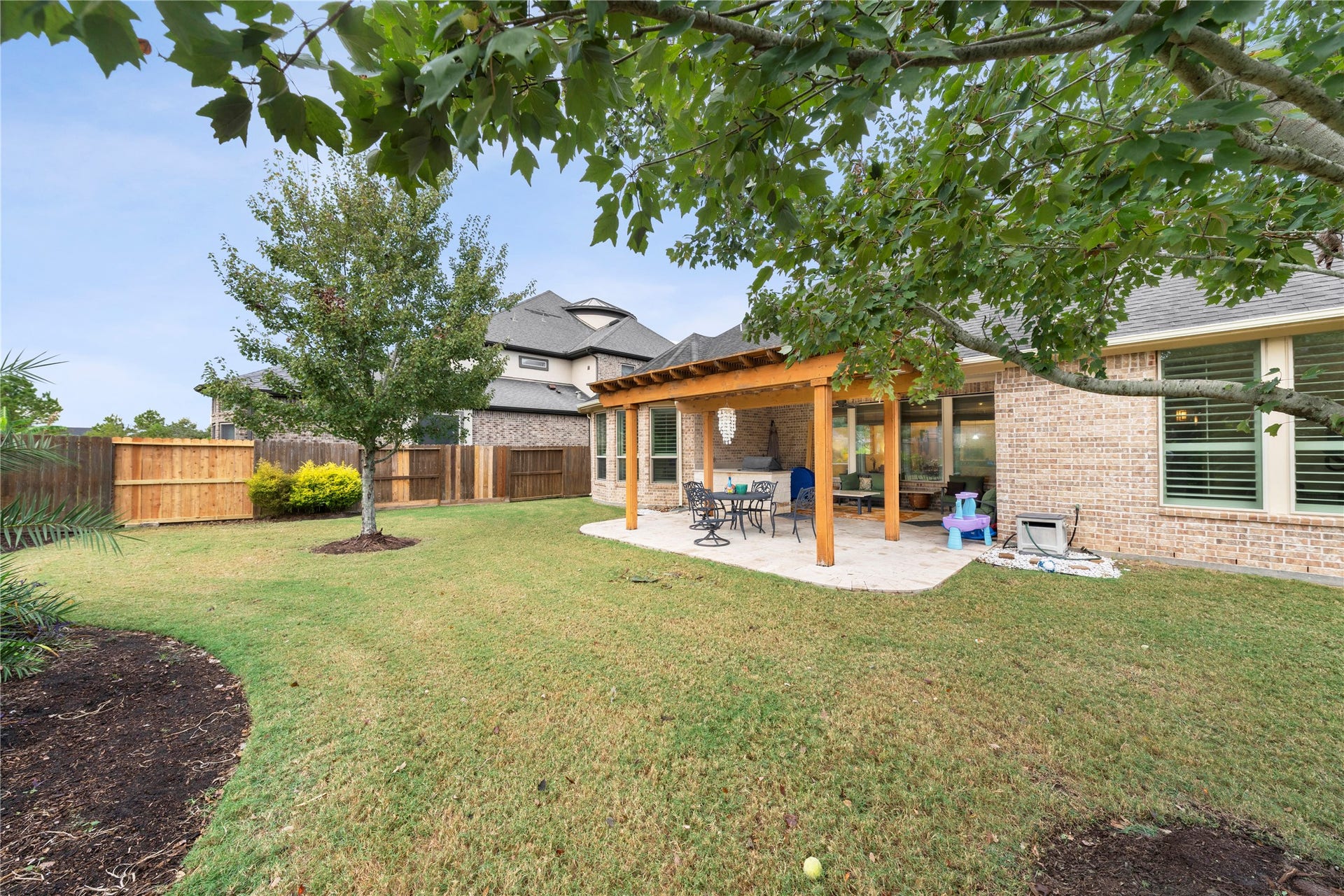 Discover the perfect outdoor oasis with a spacious covered porch, enhanced by a pergola and a fully equipped outdoor kitchen for seamless entertaining.