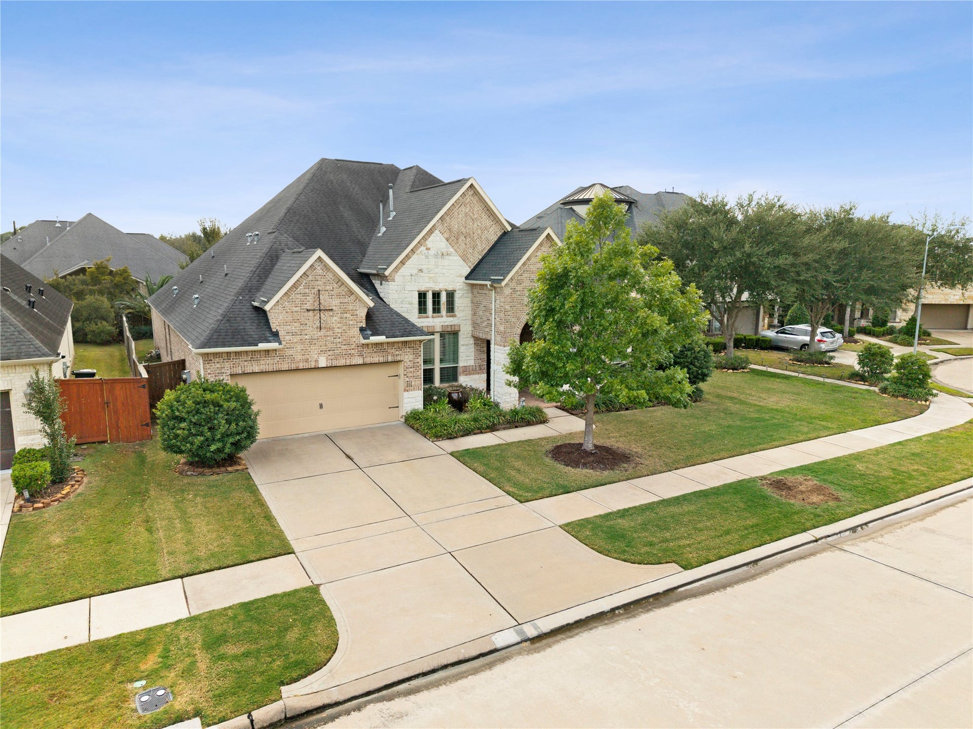 Stately brick home with a two-car garage, manicured lawn, and charming curb appeal nestled in a serene suburban neighborhood.