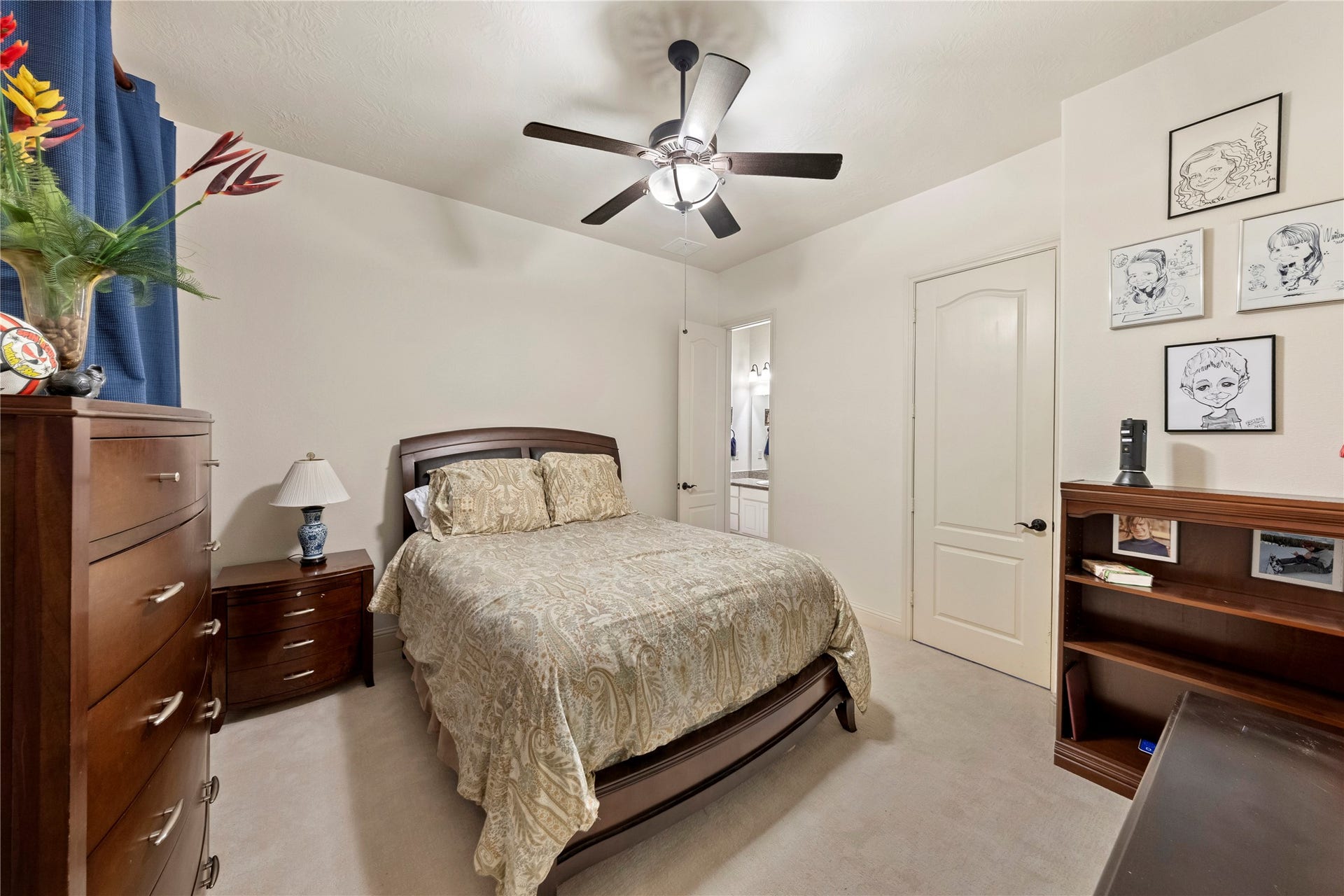 Cozy bedroom featuring a comfortable setting, complemented by a ceiling fan and ample natural light.