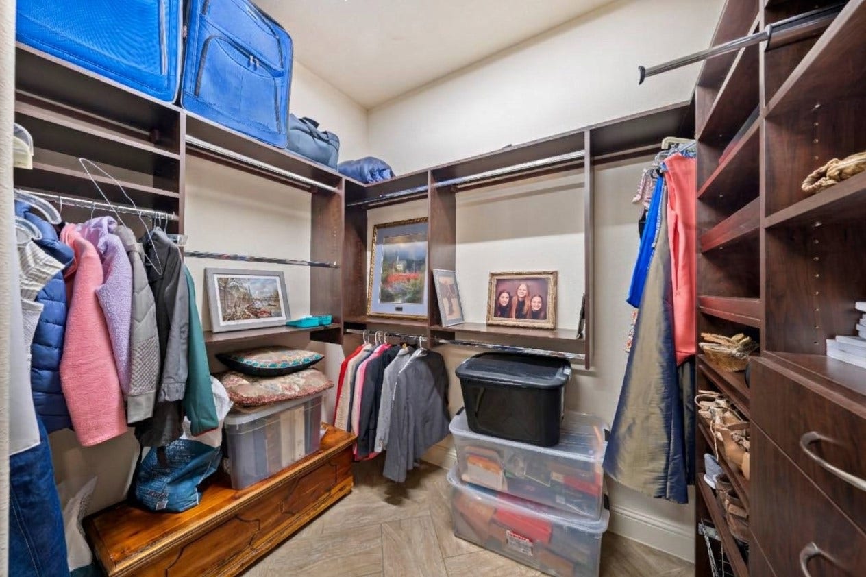 Spacious walk-in closet with ample shelving, hanging space, and storage, perfect for organizing clothing and accessories efficiently.