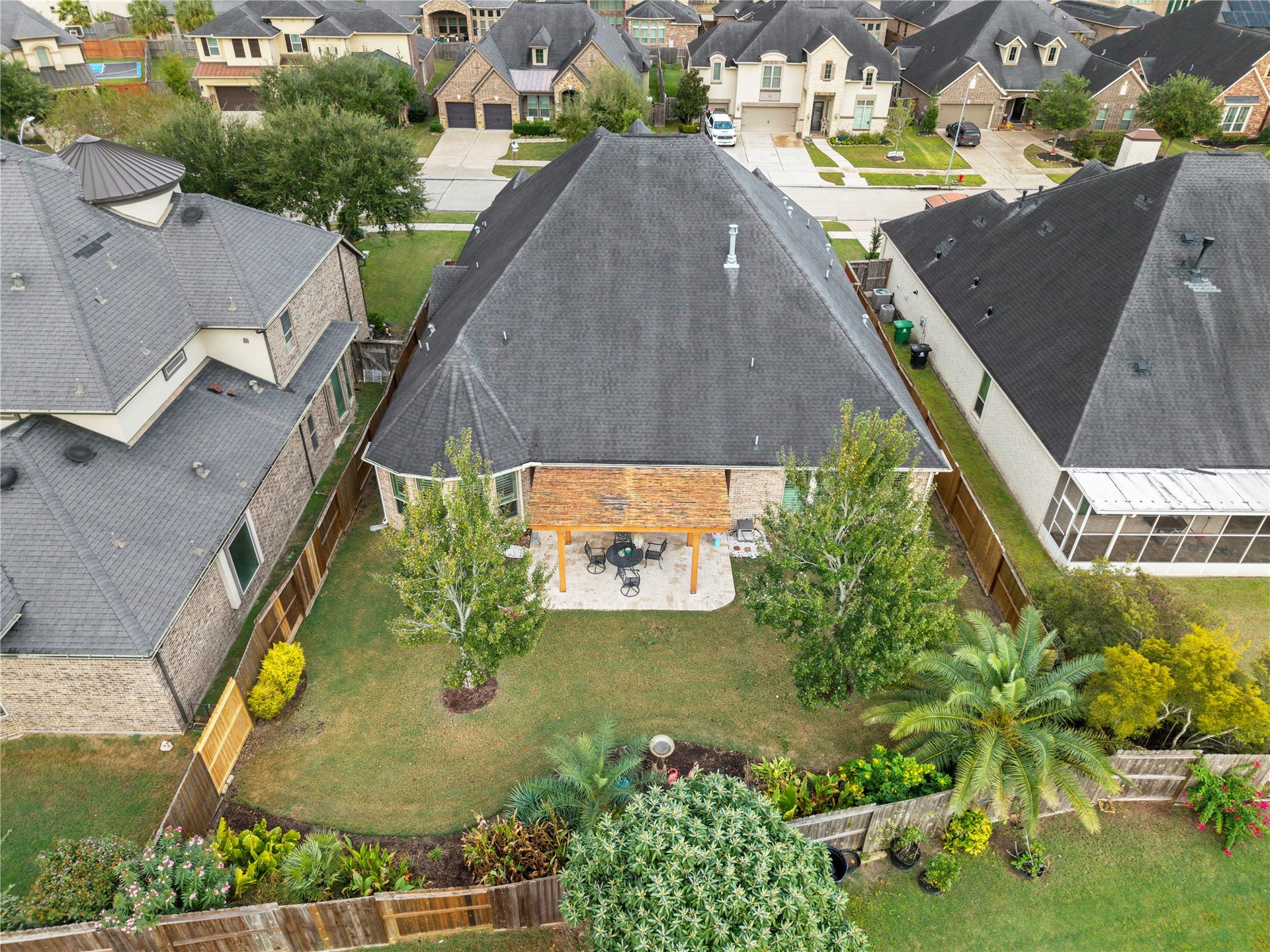 Charming suburban home featuring a spacious backyard with lush landscaping and a cozy patio area, perfect for outdoor gatherings.