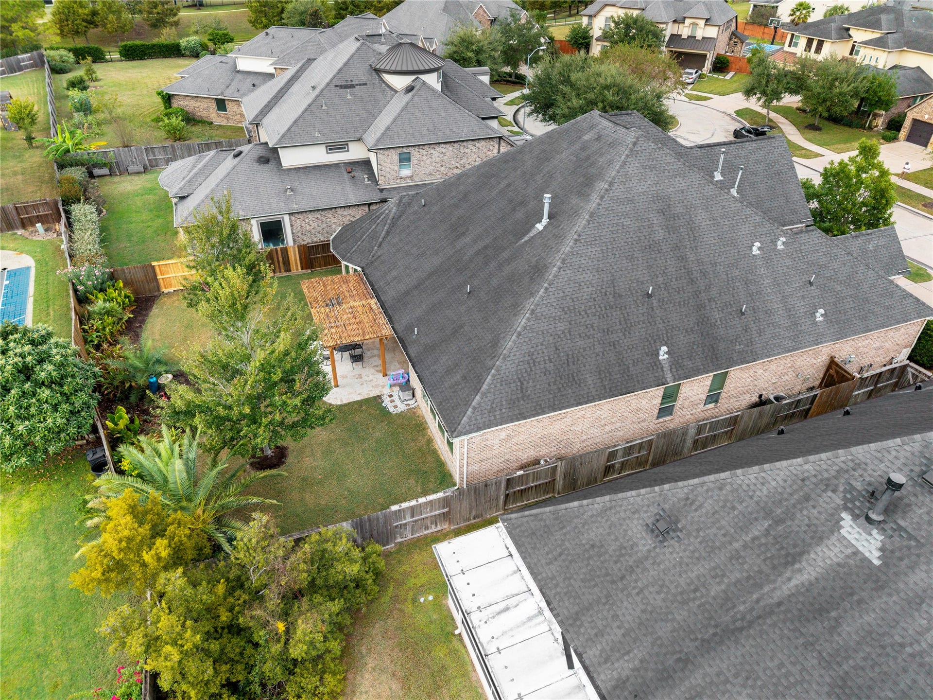 Spacious backyard with lush greenery and a cozy patio, perfect for outdoor relaxation and entertainment.