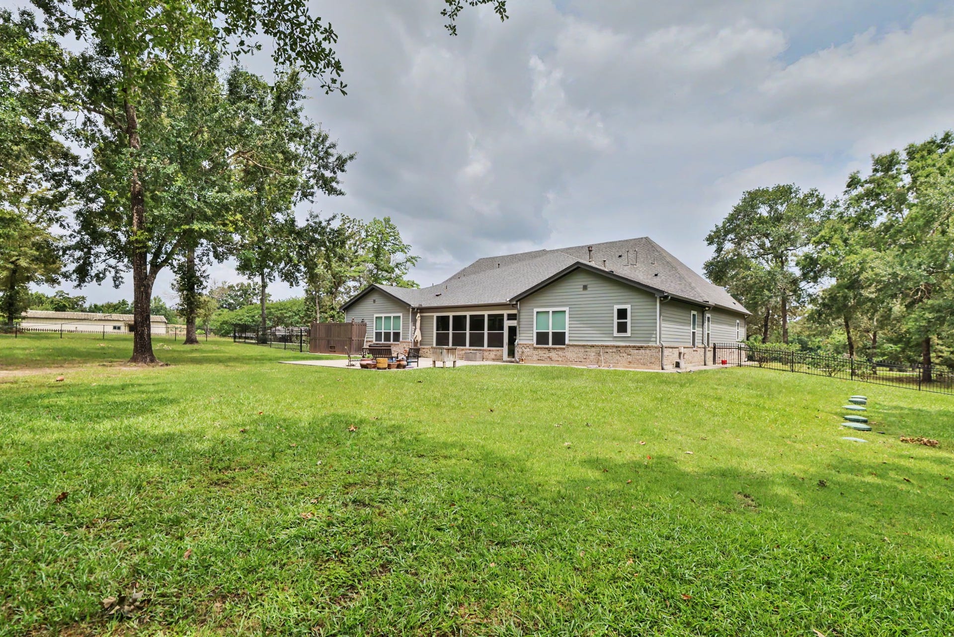 11865 Hope Lane, Magnolia, TX 77354 View from the rear of the property showcasing the spacious backyard and patio, perfect for relaxing or entertaining.