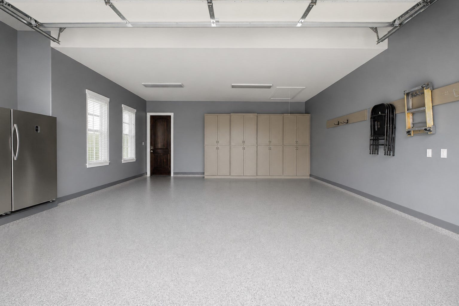 11865 Hope Lane, Magnolia, TX 77354 Oversized garage featuring durable epoxy flooring, abundant natural light from multiple windows, and built-in cabinetry for exceptional storage and organization.