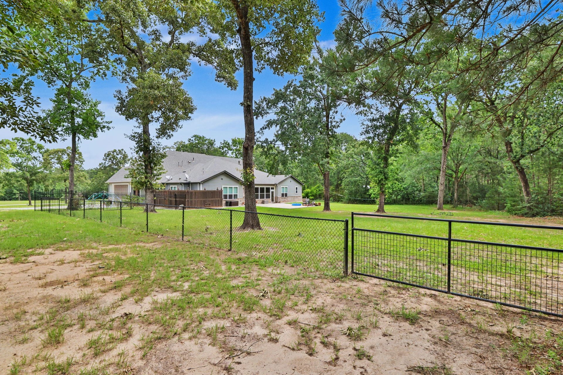 11865 Hope Lane, Magnolia, TX 77354 The fenced backyard provides a secure space for pets and play, while the property's acreage extends well beyond the fence line, offering even more room to enjoy.