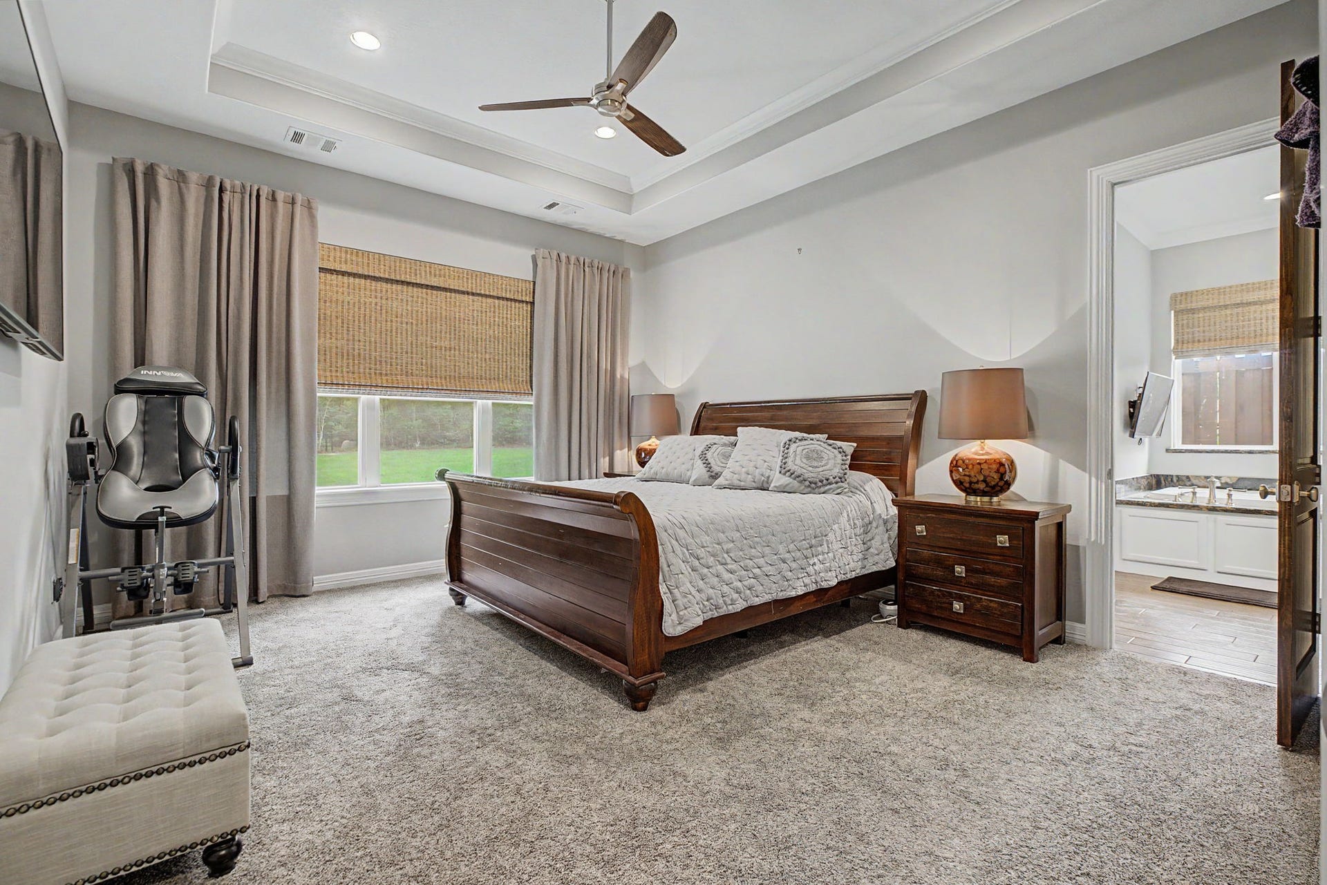 11865 Hope Lane, Magnolia, TX 77354 This spacious primary bedroom is filled with natural light and features elegant tray ceilings, creating a peaceful retreat with beautiful, serene views.