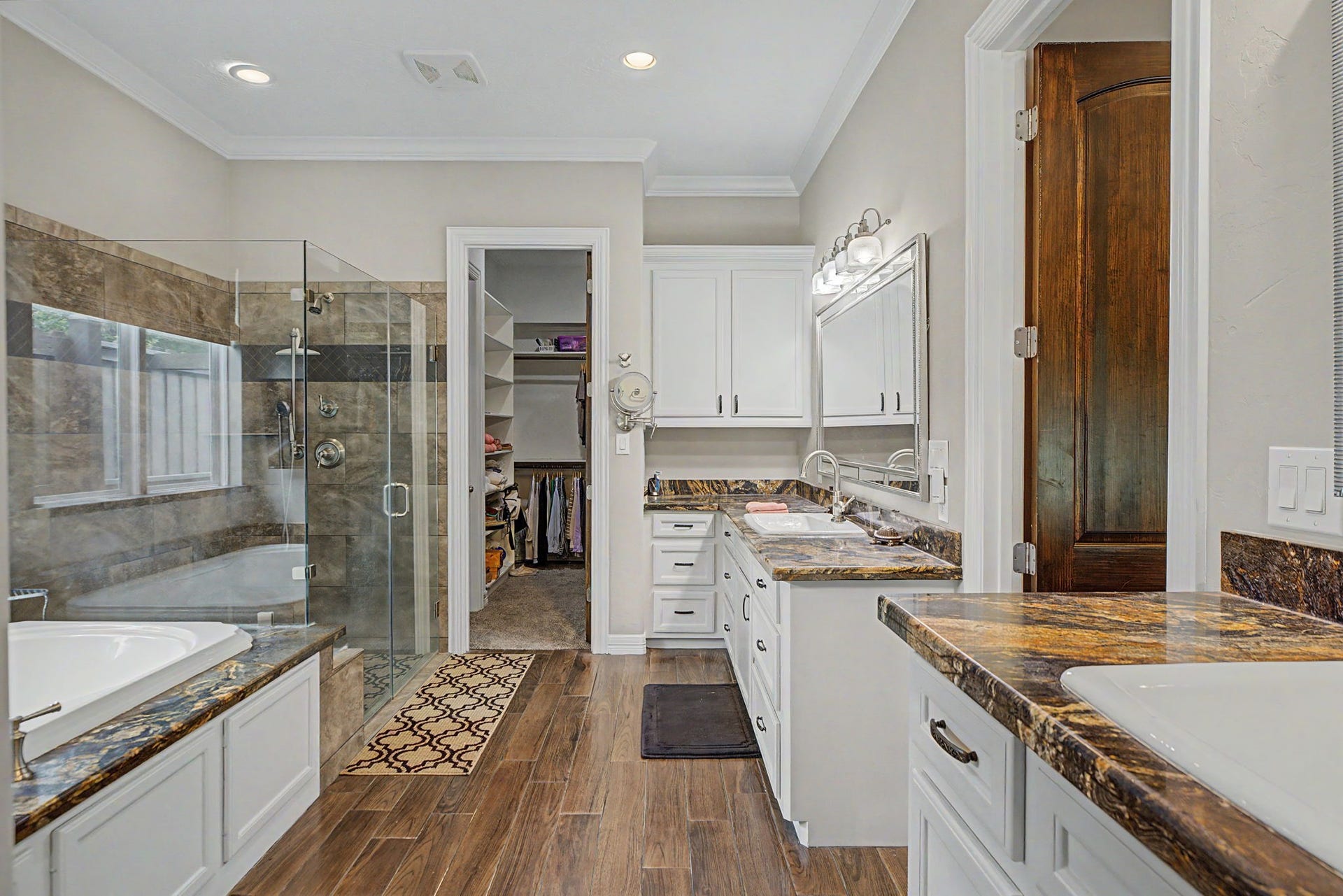 11865 Hope Lane, Magnolia, TX 77354 Indulge in this spa-like primary bathroom, complete with a spacious walk-in shower, soaking tub, dual vanities, and stylish finishes throughout.