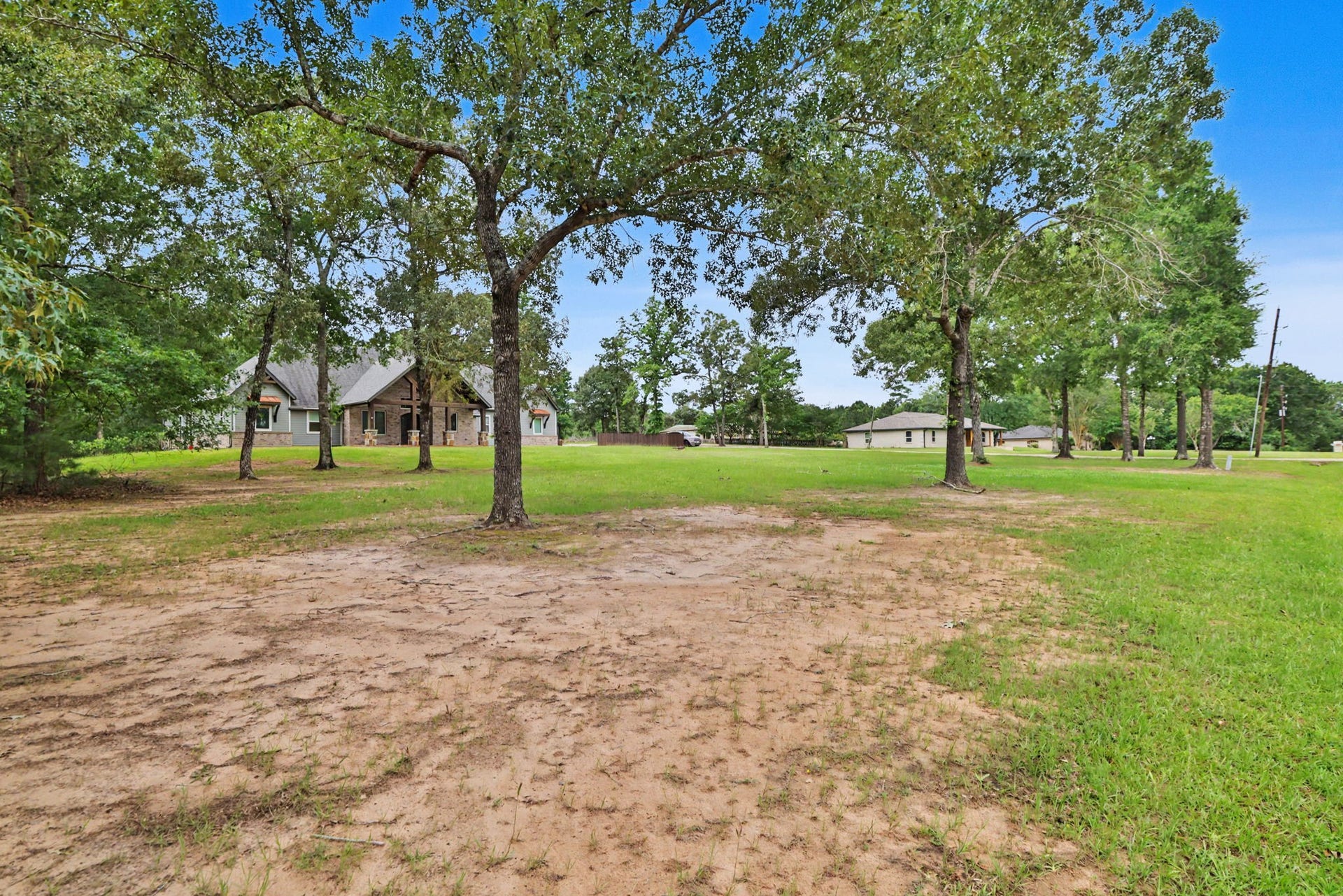 11865 Hope Lane, Magnolia, TX 77354 This view from the front corner highlights the property's generous outdoor space, beautiful setting, and custom home.