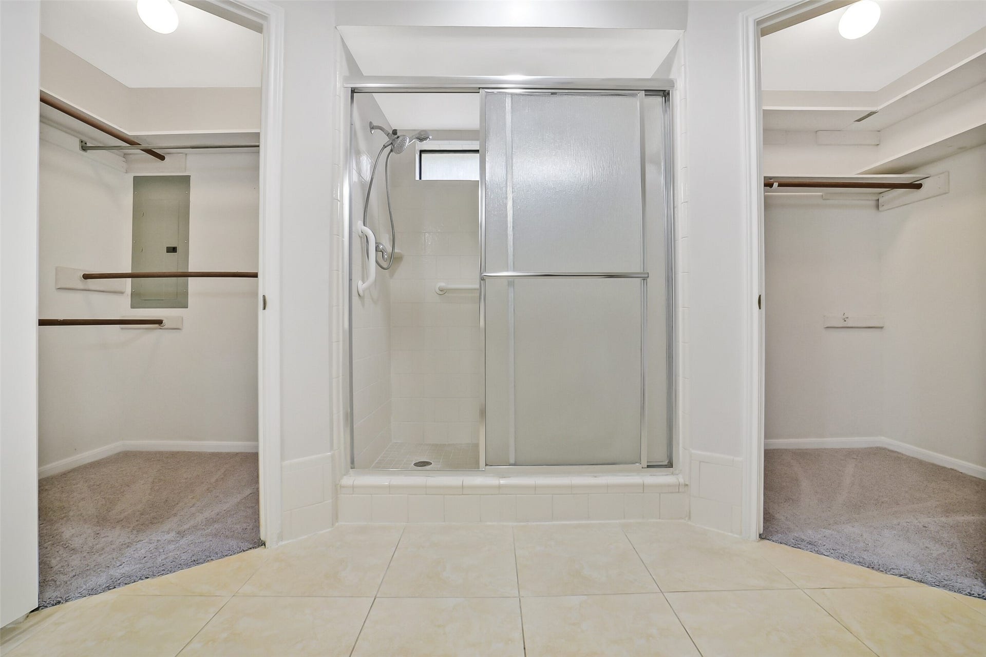 There are two walk-in closets and a standing shower with tile surround and a sliding glass door.