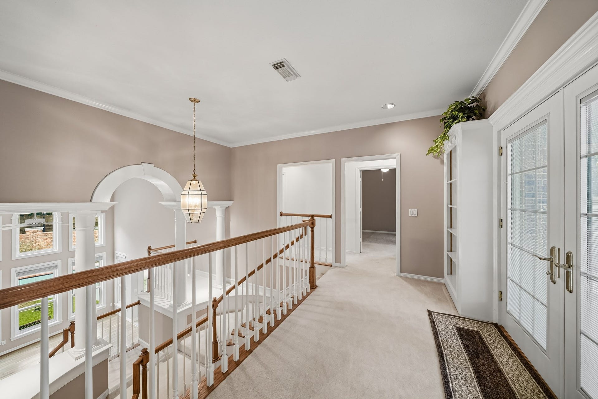 The landing at the top of the stairs with French Doors that lead out to the balcony.