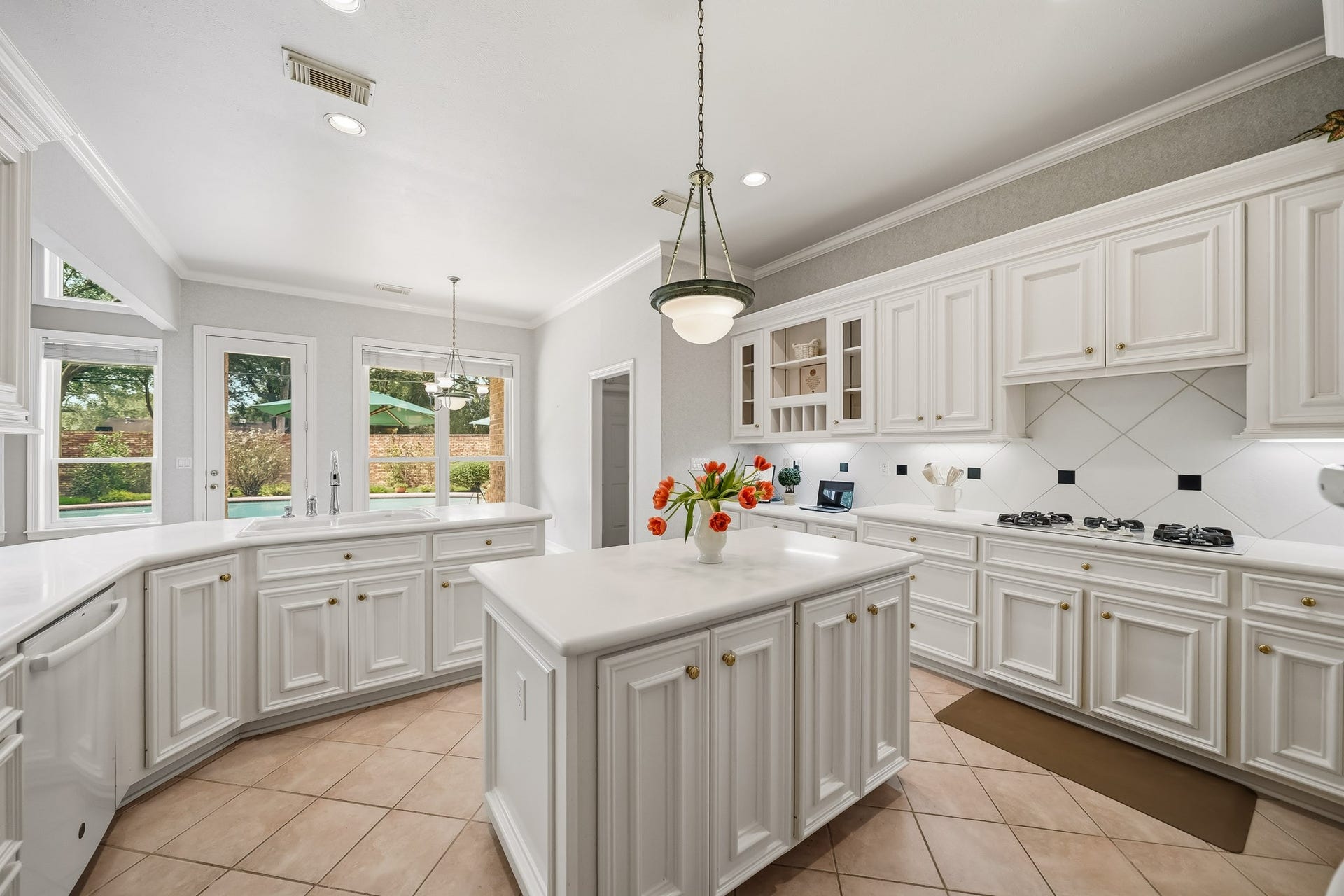 Timeless white on white kitchen with ample cabinetry, drawers for easy access to pots and pans, and large cabinets for your culinary devices.