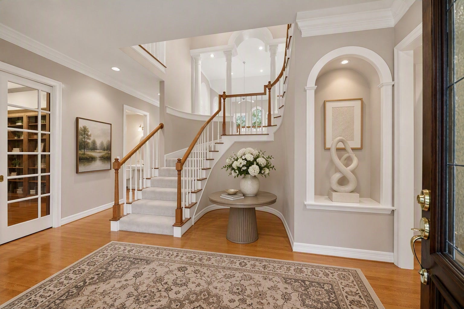 Dramatic entryway with beautiful staircase, solid hardwood flooring, art niche. Virtually Staged.