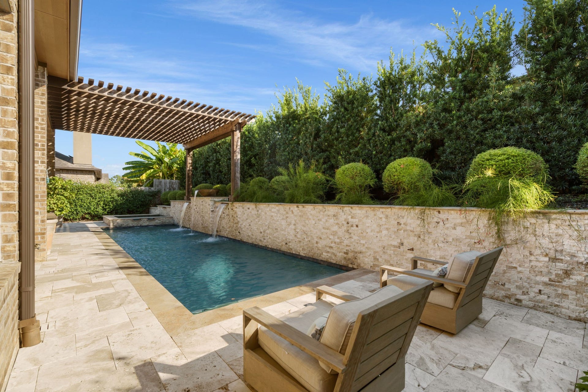 126 Summer Holly Drive, Conroe, TX 77384 Relax poolside surrounded by lush, mature landscaping that creates a peaceful and private backyard setting.