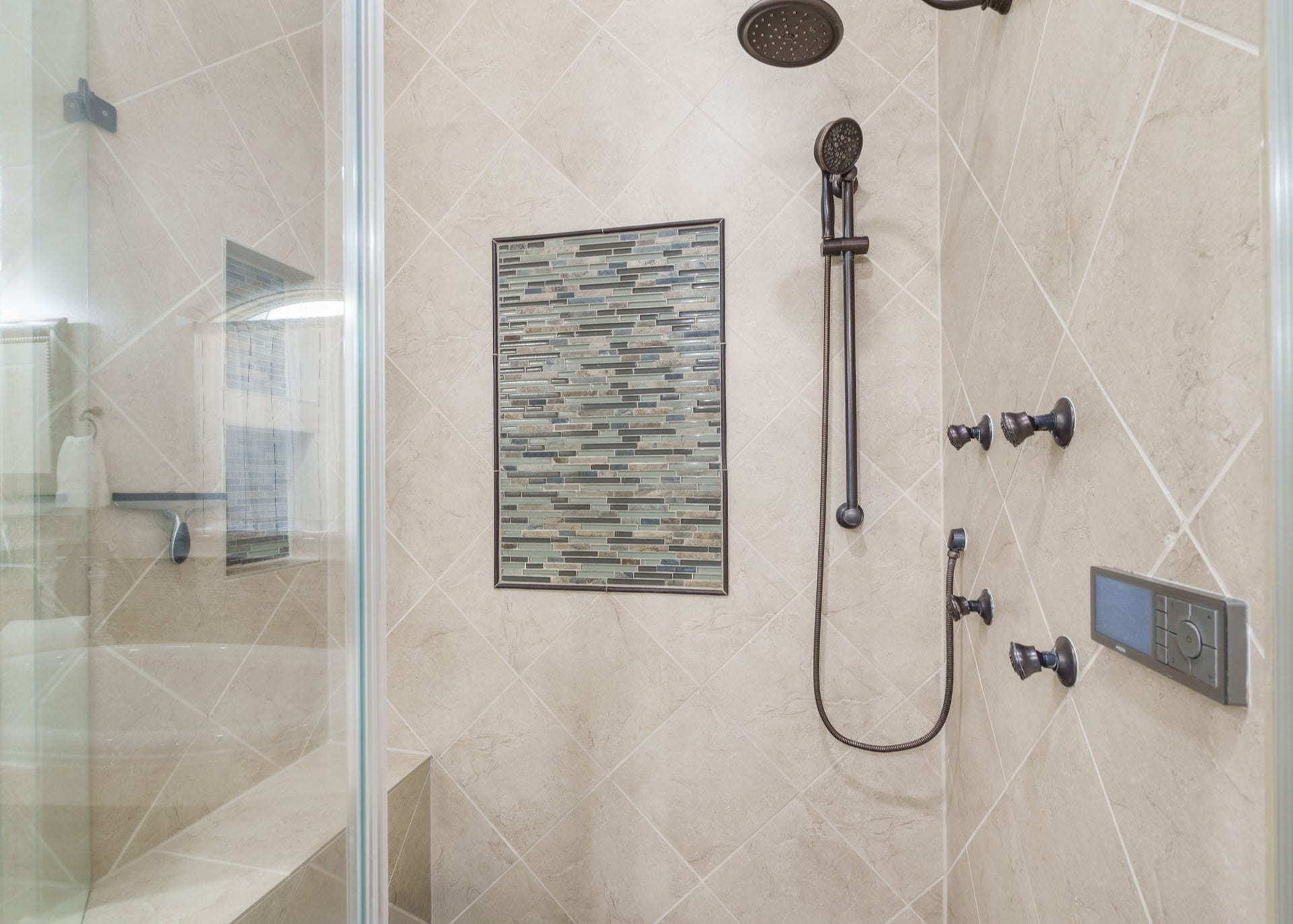 126 Summer Holly Drive, Conroe, TX 77384 Beautifully tiled shower featuring multiple body sprays, a rainfall showerhead, handheld shower, and decorative mosaic accents.