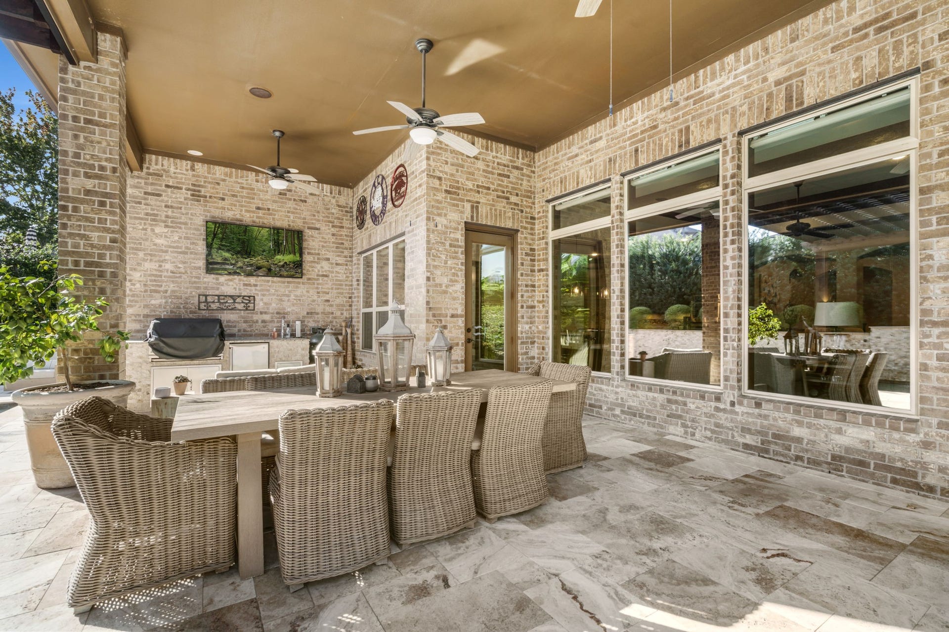 126 Summer Holly Drive, Conroe, TX 77384 Expansive covered patio with beautiful stone flooring, ceiling fans, and plenty of room for outdoor dining and entertaining.