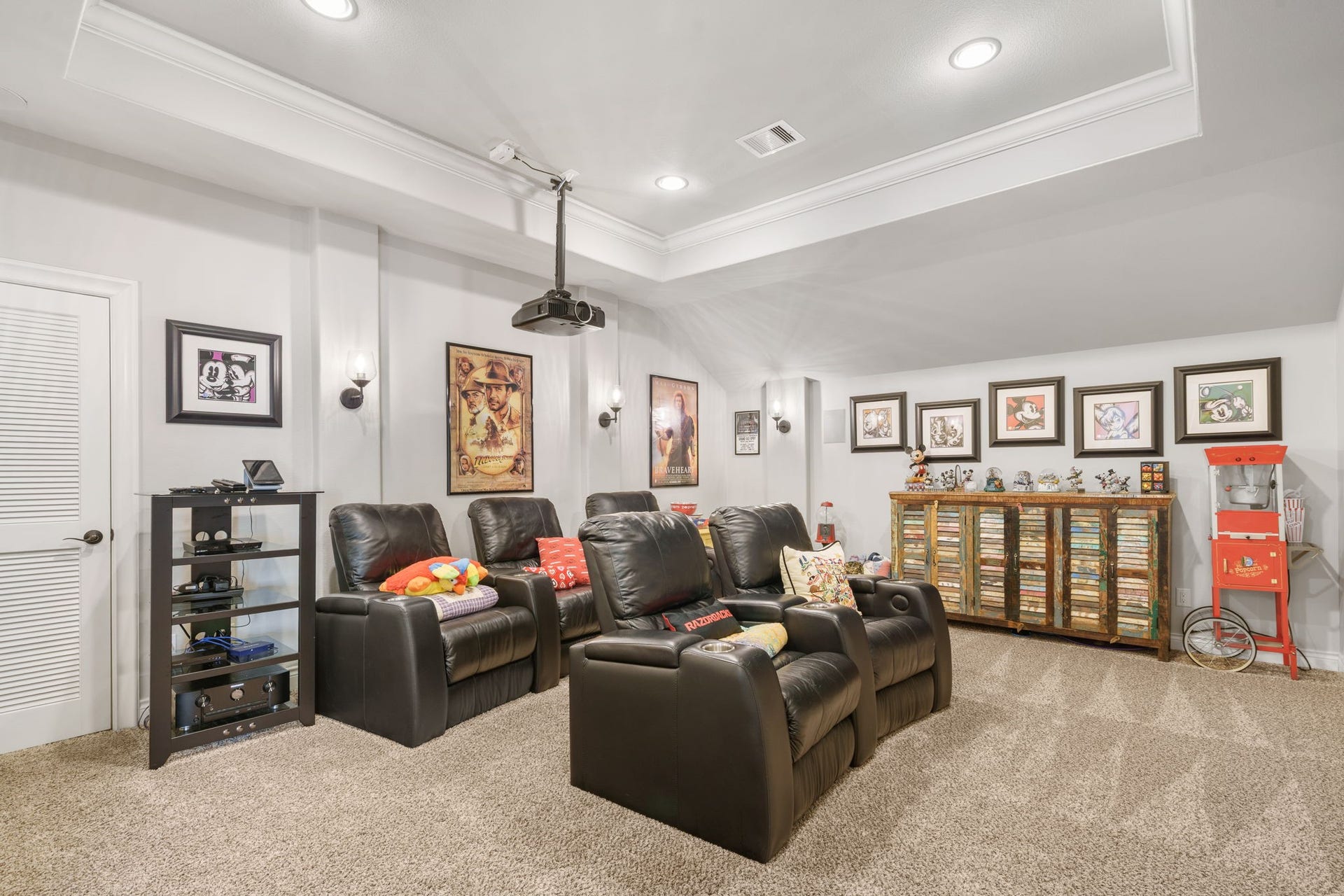 126 Summer Holly Drive, Conroe, TX 77384 Dedicated media room features comfortable theater-style seating, recessed lighting, and a ceiling-mounted projector for movie nights at home.
