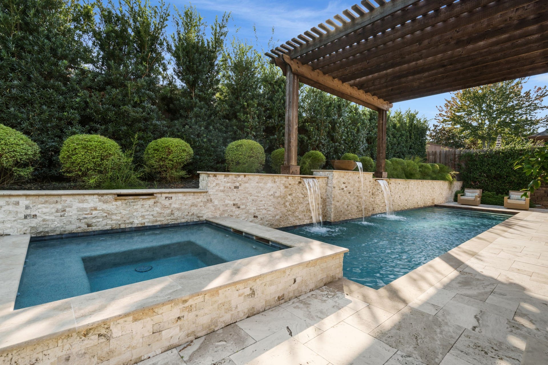 126 Summer Holly Drive, Conroe, TX 77384 Custom pool showcases cascading waterfalls, a raised stone accent wall, and a beautiful pergola overlooking the water.